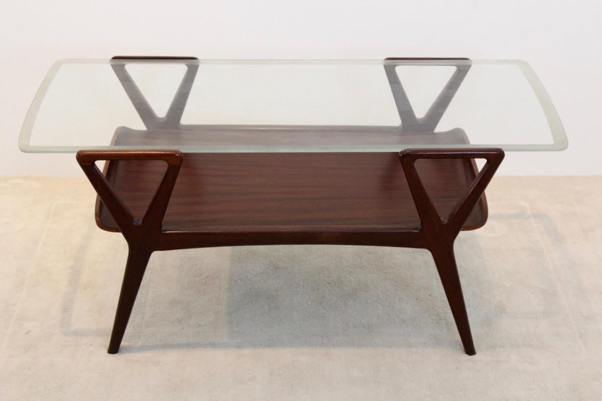 Scandinavian teak two-tiered coffee table with a glass top manufactured in the 1960s. The glass top is nicely etched around the sides. Very nice graphic design with clean and simple lines.