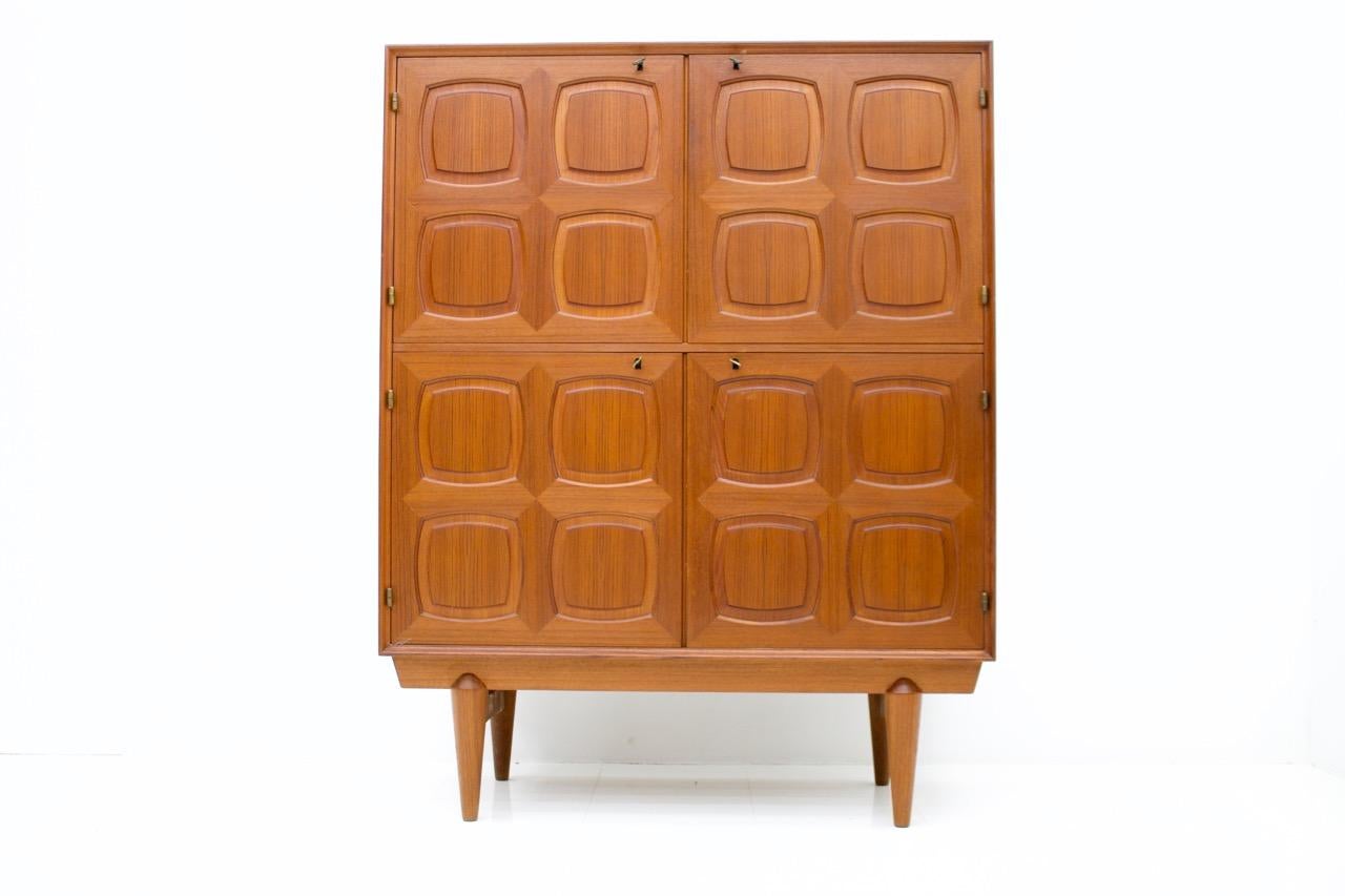 Very nice teak highboard by Adolf Rastad and Rolf Relling made by Gustav Bahus from Norway, designed in 1960s.
Massive teak wood doors with graphic front. Behind the right door are four adjustable teak wood drawers. All brass keys are