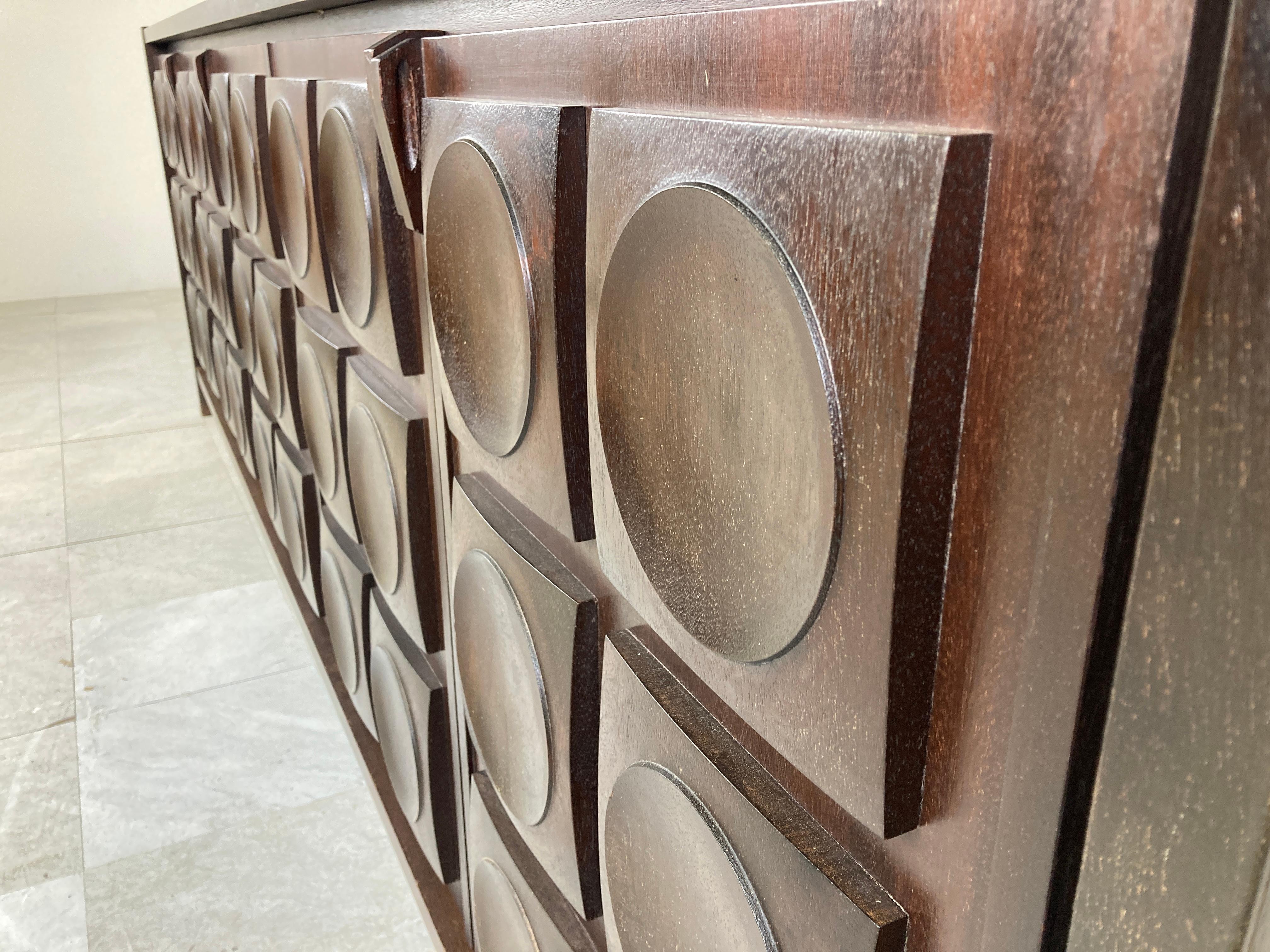 Brown brutalist credenza with 5 graphical doors.

Beautiful timeless design and a real eye catcher for your living room.

Beautiful organic handles and nice graphical design.

It offers plenty of storage space and had two drawers.

Very good