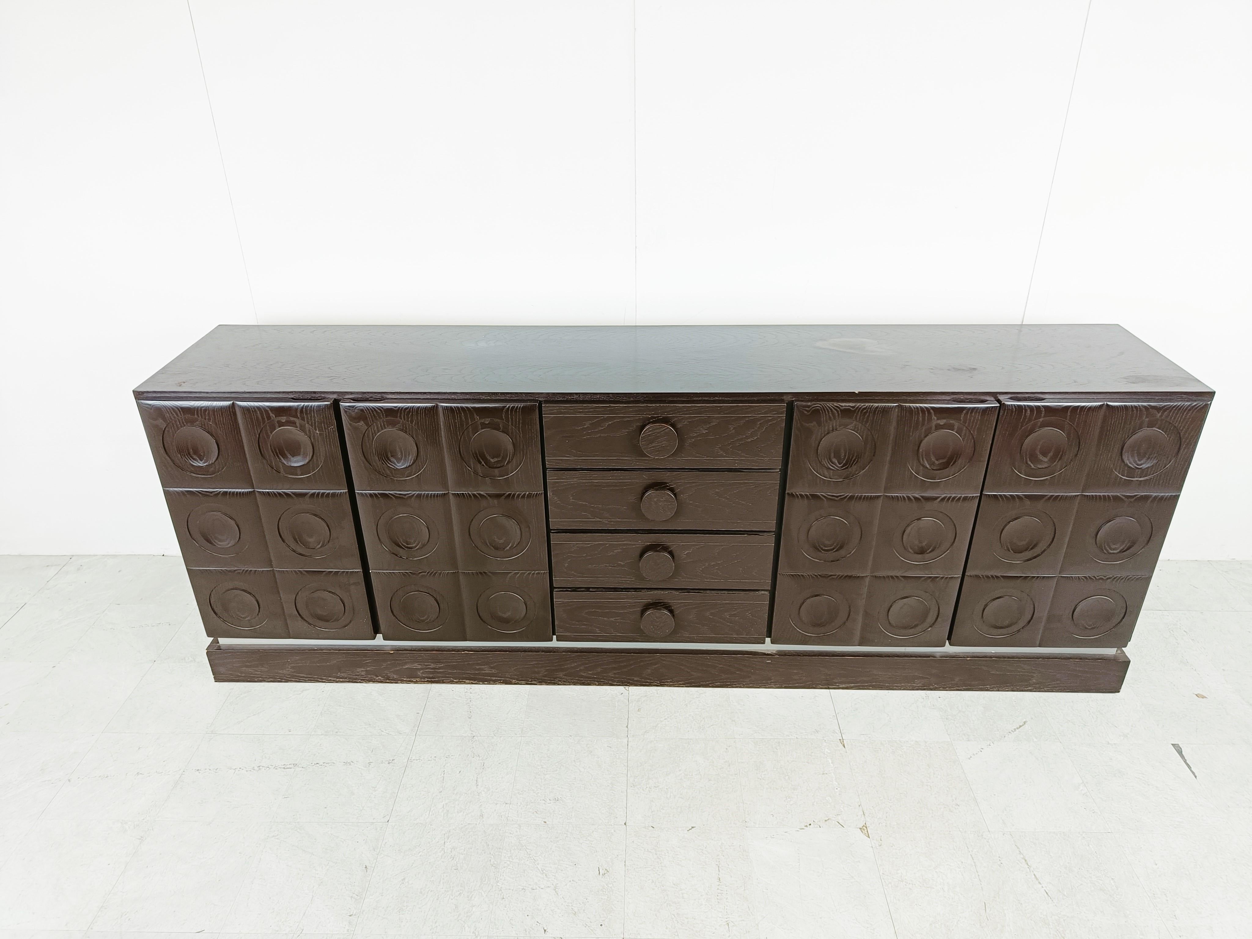 Brown brutalist credenza with 4 graphical doors and 4 central drawers.

Beautiful timeless design and a real eye catcher for your living room.

Good condition.

1970s - Belgium

Dimensions:

Lenght: 275cm/108.26