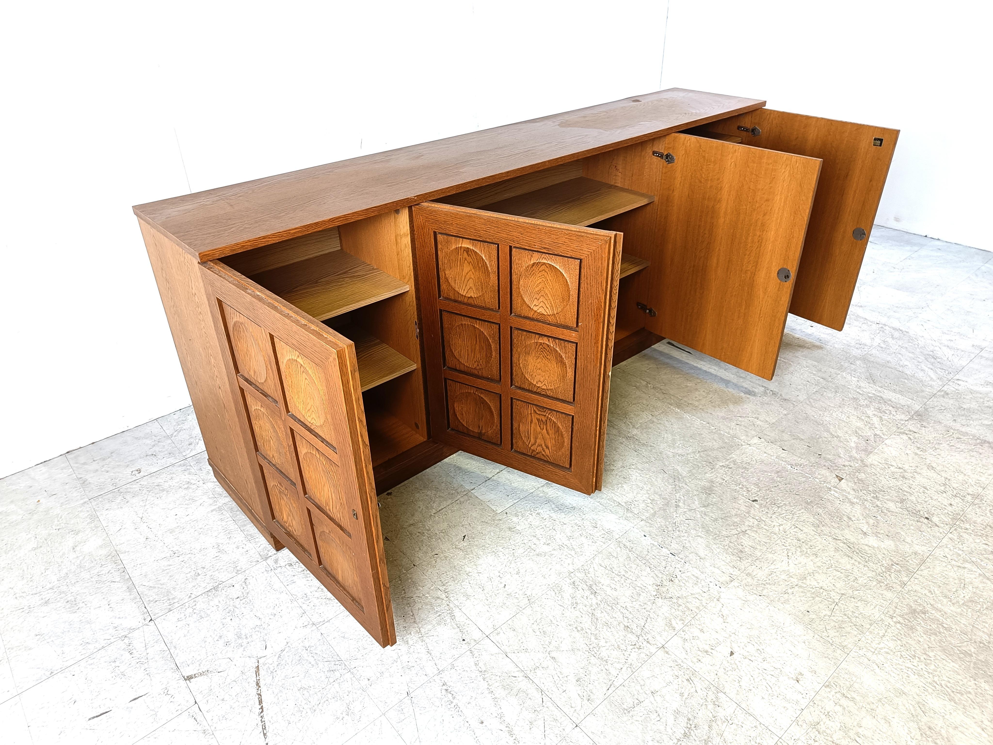 Brown brutalist two tone oak credenza with 4 graphical doors.

Beautiful timeless design and a real eye catcher for your living room.

This credenza provides plenty of storage space with two integrated drawers.

Good condition

1970s -