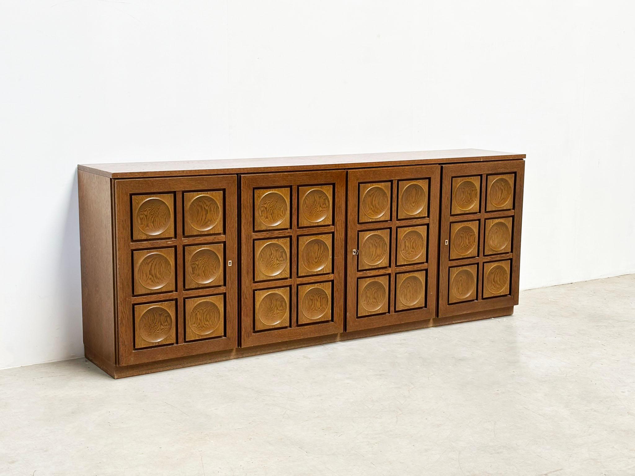 The German designer Gerard Bartel has created a brutalist sideboard crafted from veneered patinated oak. This piece features bold, geometric lines and a raw, natural aesthetic characteristic of the Brutalism movement. Its striking design merges