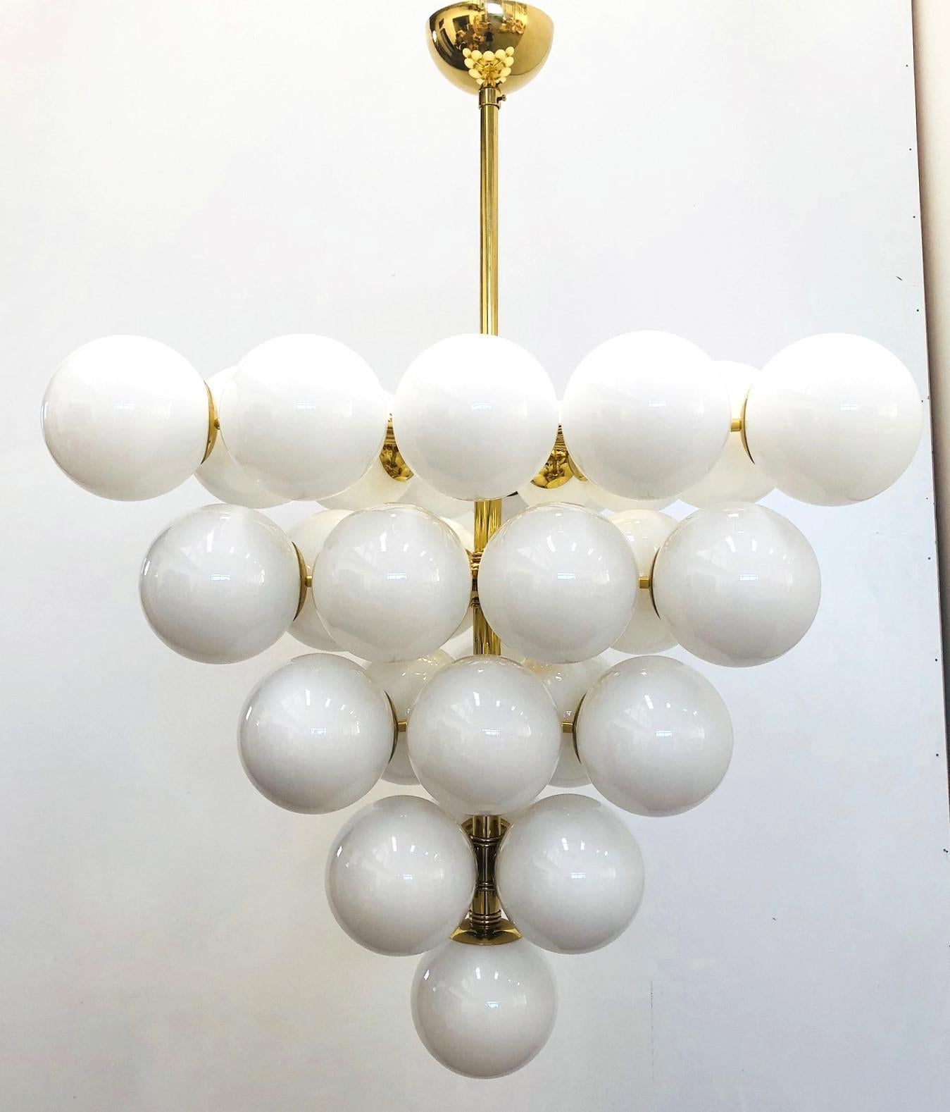 Lampadario italiano con globi in vetro di Murano bianco montati su una struttura in ottone lucido / Disegnato da Fabio Bergomi per Fabio Ltd / Made in Italy
31 luci / tipo E12 o E14 / max 40W ciascuna
Diametro: 31,5 pollici / Altezza: 31,5 pollici,