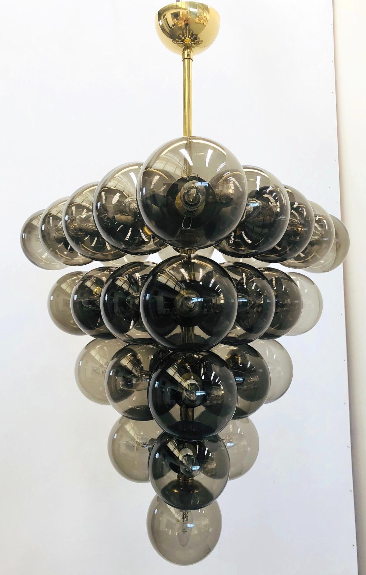 Lampadario italiano con globi in vetro di Murano fumé montati su una struttura in ottone lucido / Disegnato da Fabio Bergomi per Fabio Ltd / Made in Italy
31 luci / tipo E12 o E14 / max 40W ciascuna
Diametro: 31,5 pollici / Altezza: 31,5 pollici,
