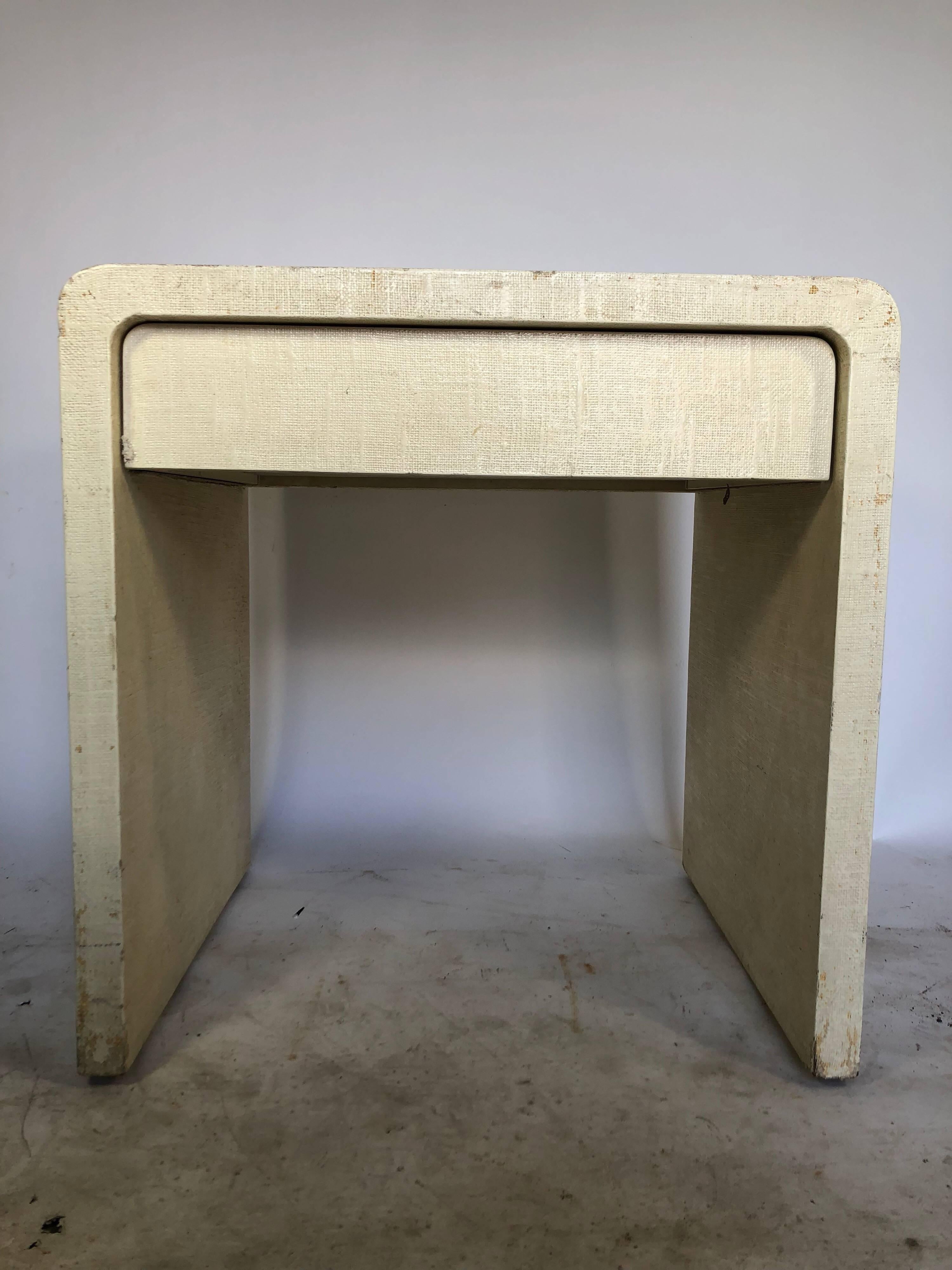 Waterfall edge side table with beige grass cloth and a single drawer by Karl Springer.