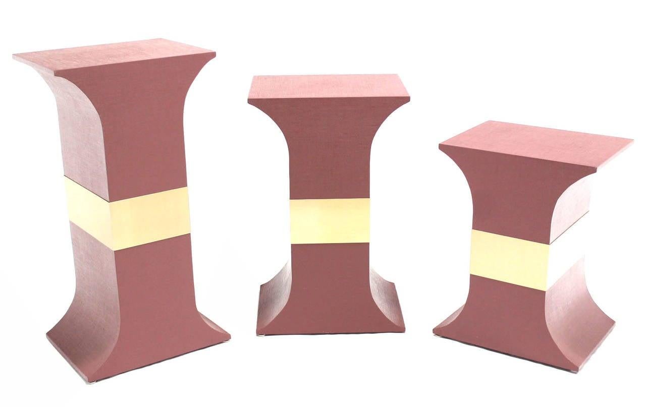 Set of three matching pedestals wrapped in grass cloth in style of Springer. 
Color customization is possible Dimensions: 20x15x38, 20x15x32, 20x15x26