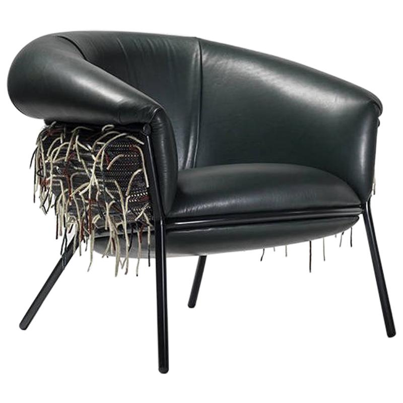 An iron tubular (25 mm) structured armchair. Seat and backrest upholstered in leather and fabric.

The leather upholstery oozes over the bare iron structure to contrast with the most luxurious touch of the skin.