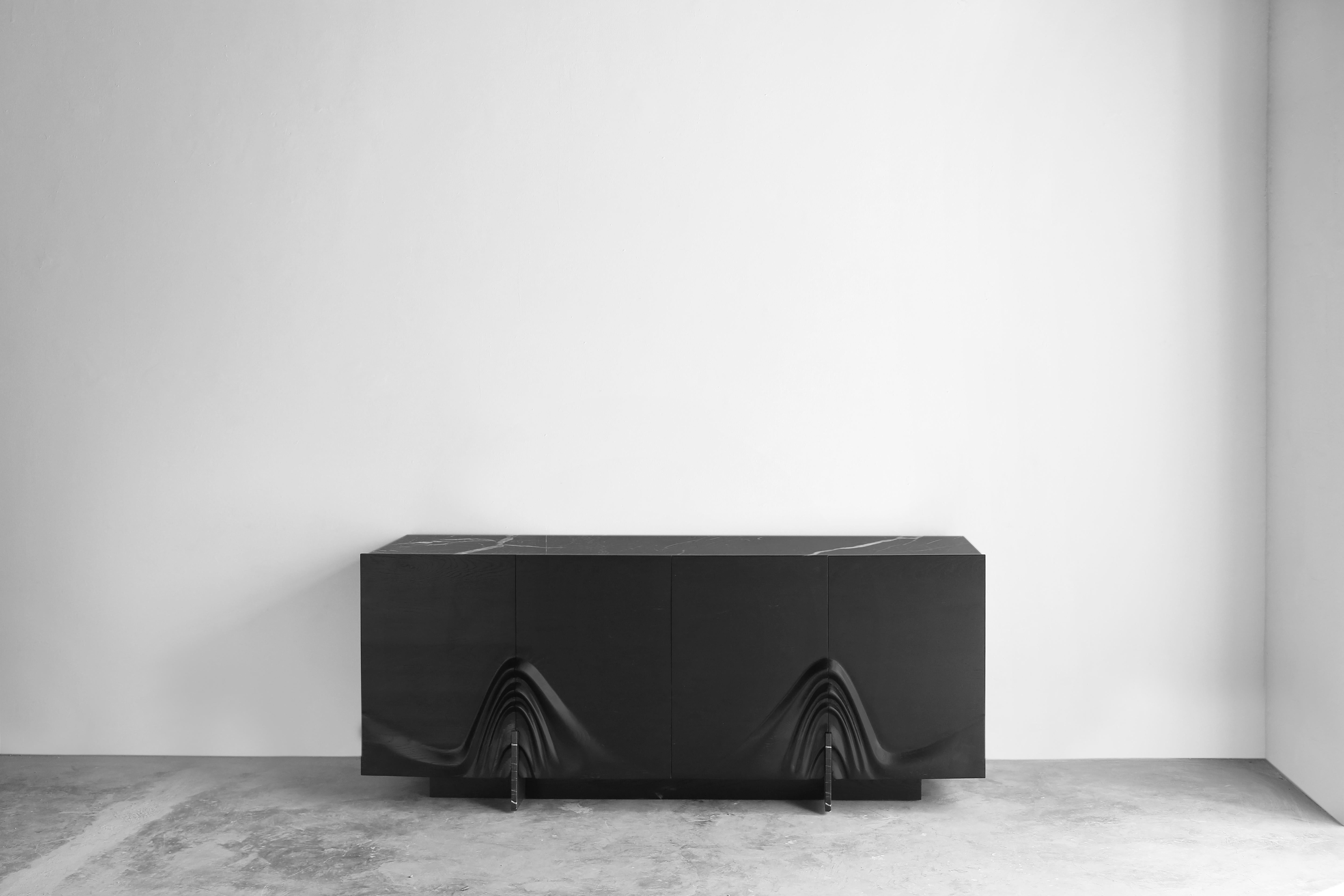 Gravedad sideboard by Joel Escalona
Limited Edition of 9
Dimensions: D 200 x W 80 x H 50 cm
Materials: oak wood, Petra Grey marble, steel.

Console made of solid burnt and tinted oak wood, pedestals and top surface in Petra Grey marble.