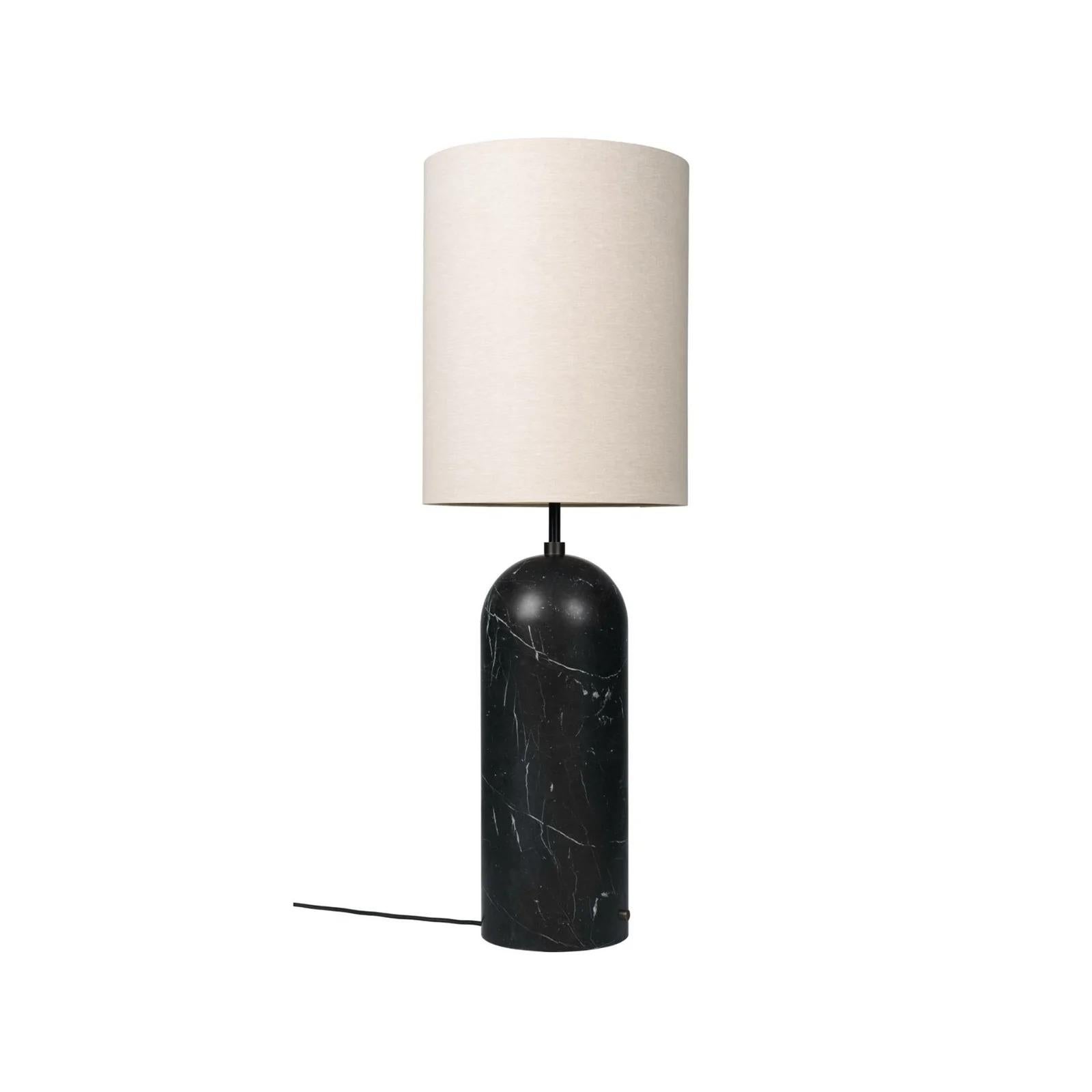 Le lampadaire Gravity XL, conçu par Space Copenhagen, présente un contraste esthétique entre la force et la fragilité. Son nom vient de l'équilibre particulier de la lampe entre l'ancrage de la base lourde et cylindrique et l'abat-jour léger et