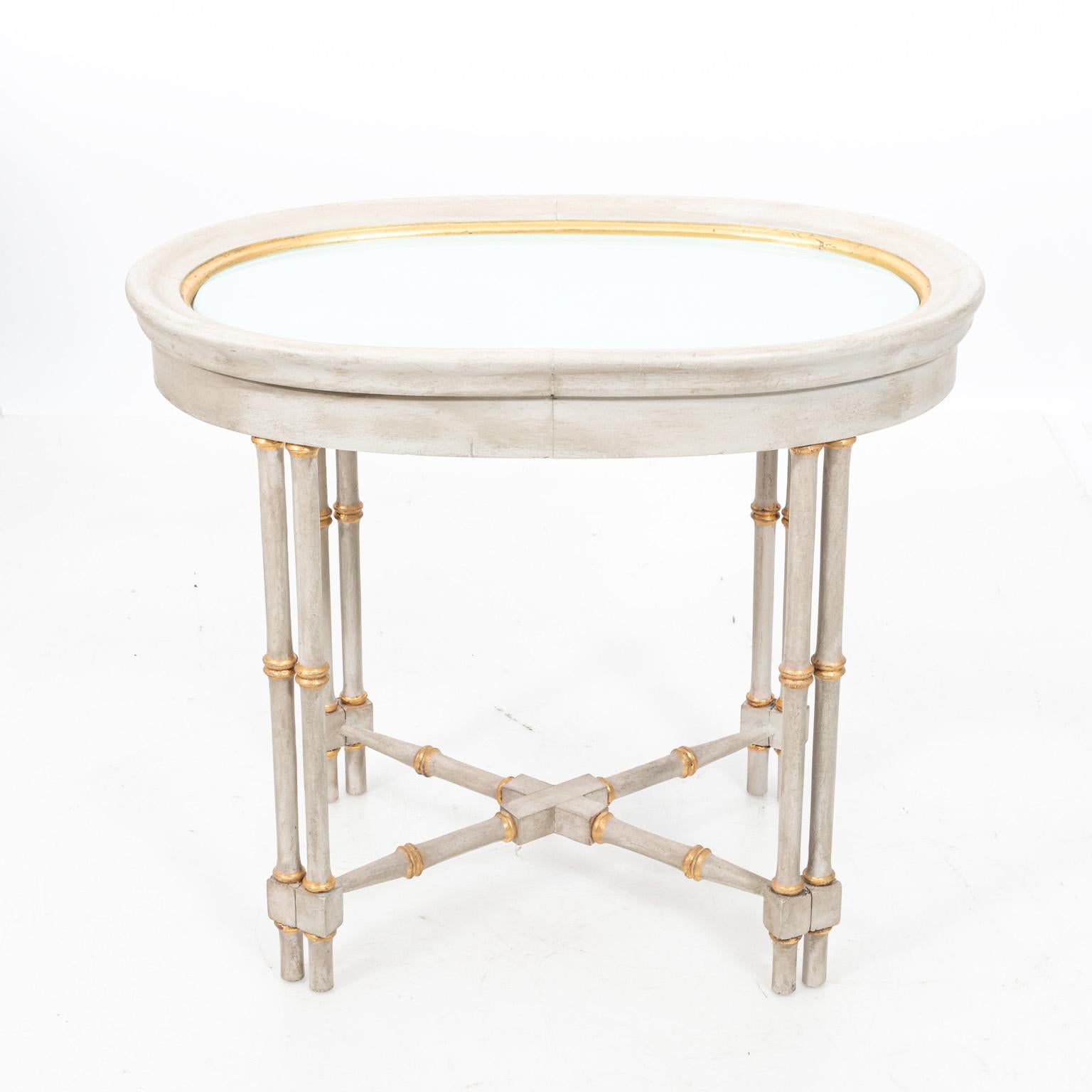Pair of gray and gilded faux bamboo oval side tables with glass top insert and x-shaped cross stretcher, circa mid-20th century. Made in Italy.