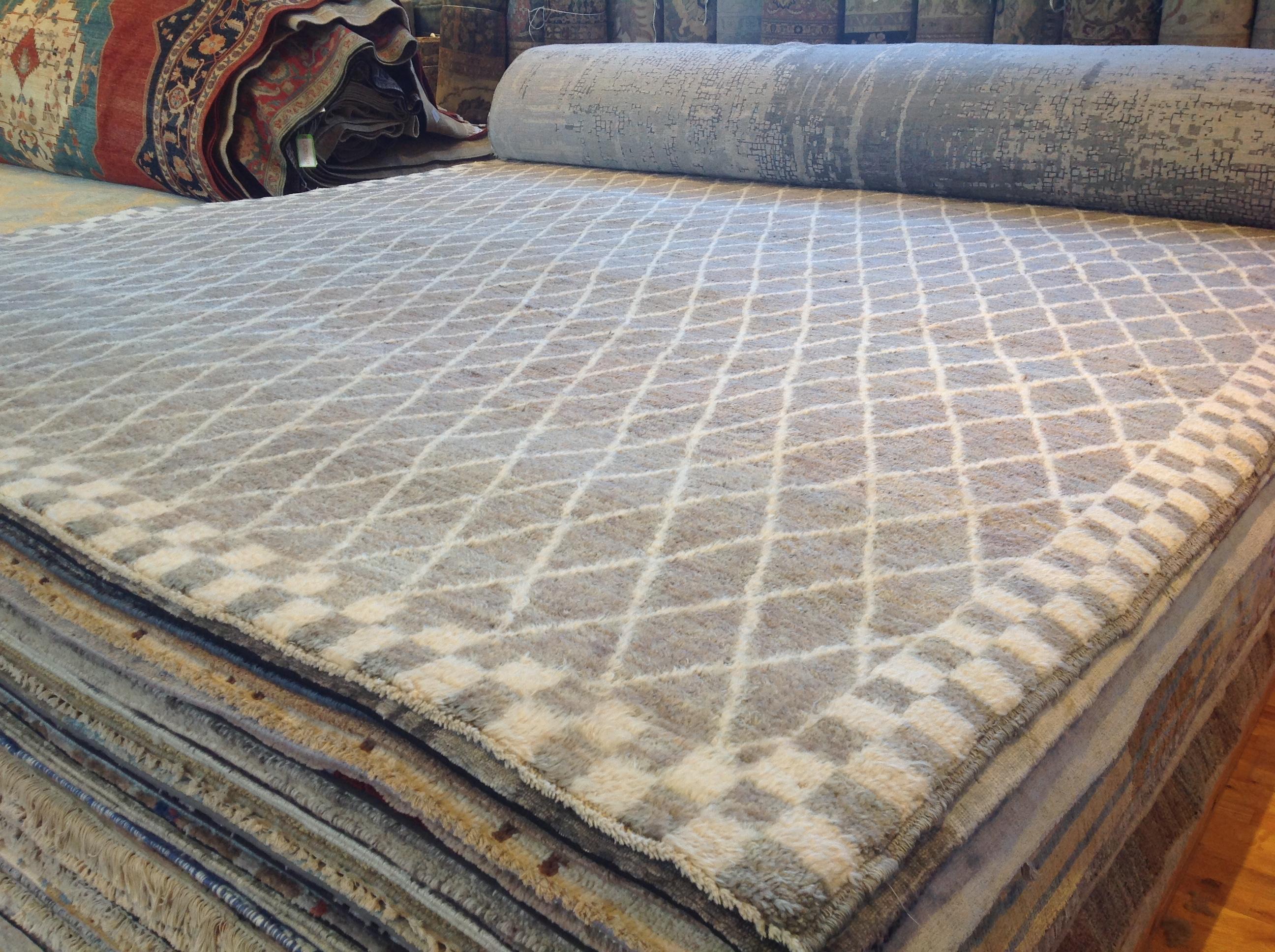 This traditional Moroccan design features a silver diamond all-over design against a gray background surrounded by a checkerboard border. Luxurious thick pile from hand knotted wool. Made in Pakistan.