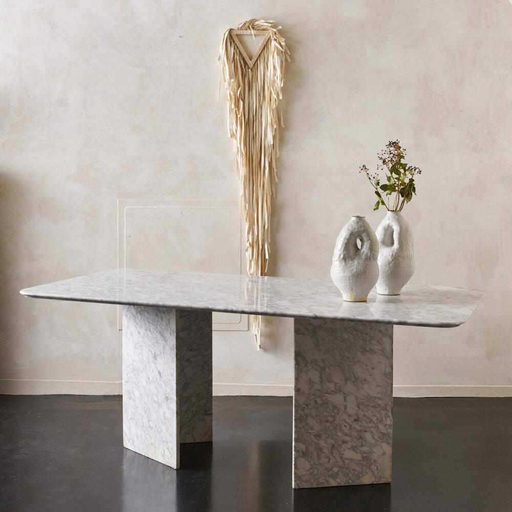 A large marble dining table consisting of a rectangular top and two triangular bases that can be positioned in a variety of different configurations. France, 1980s. 

Dimensions: 74.75