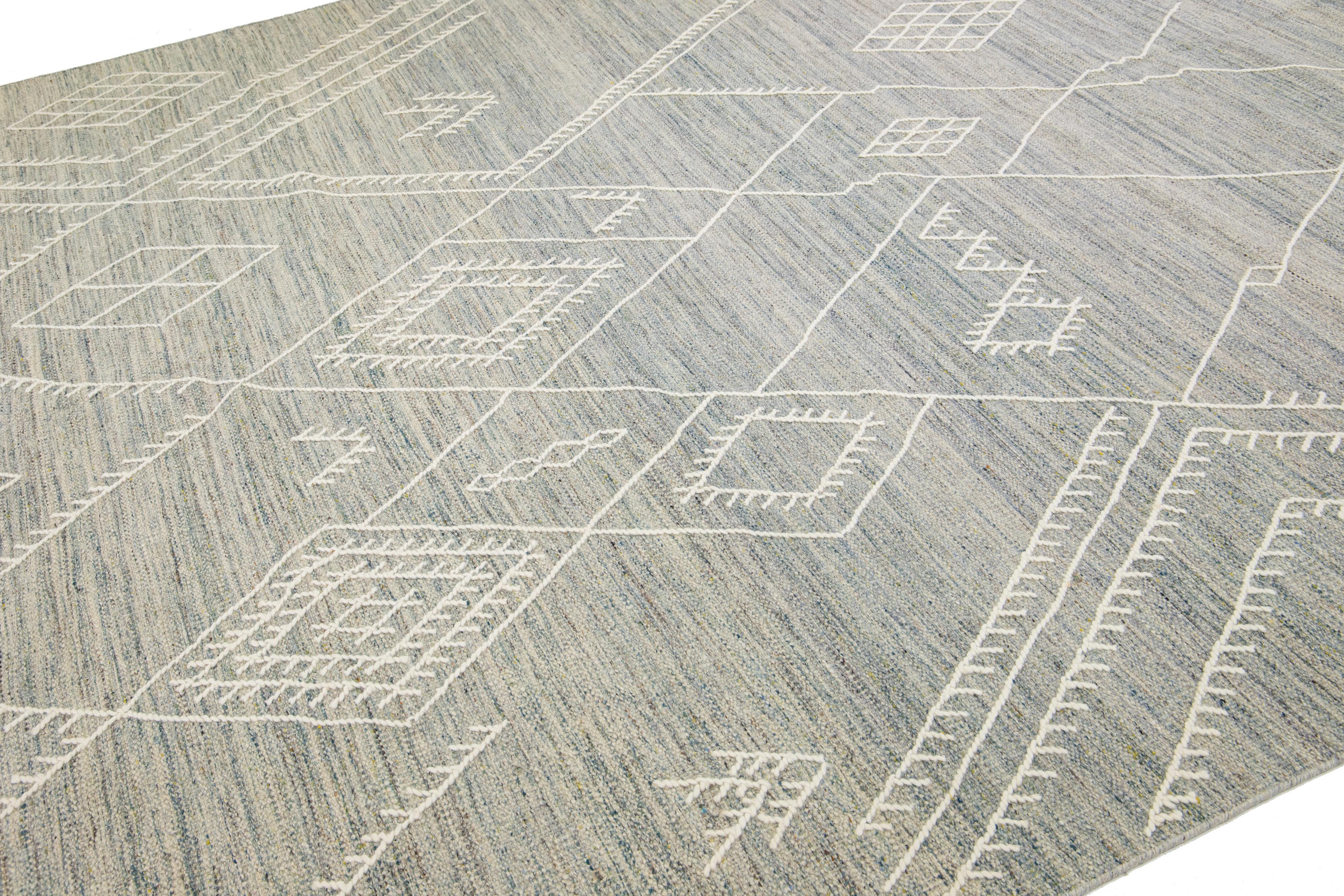 Beautiful kilim handmade wool rug with a gray and blue field. This custom modern flatweave rug of our Nantucket collection has ivory accents and a gorgeous all-over geometric coastal design.

This rug measures 10'2