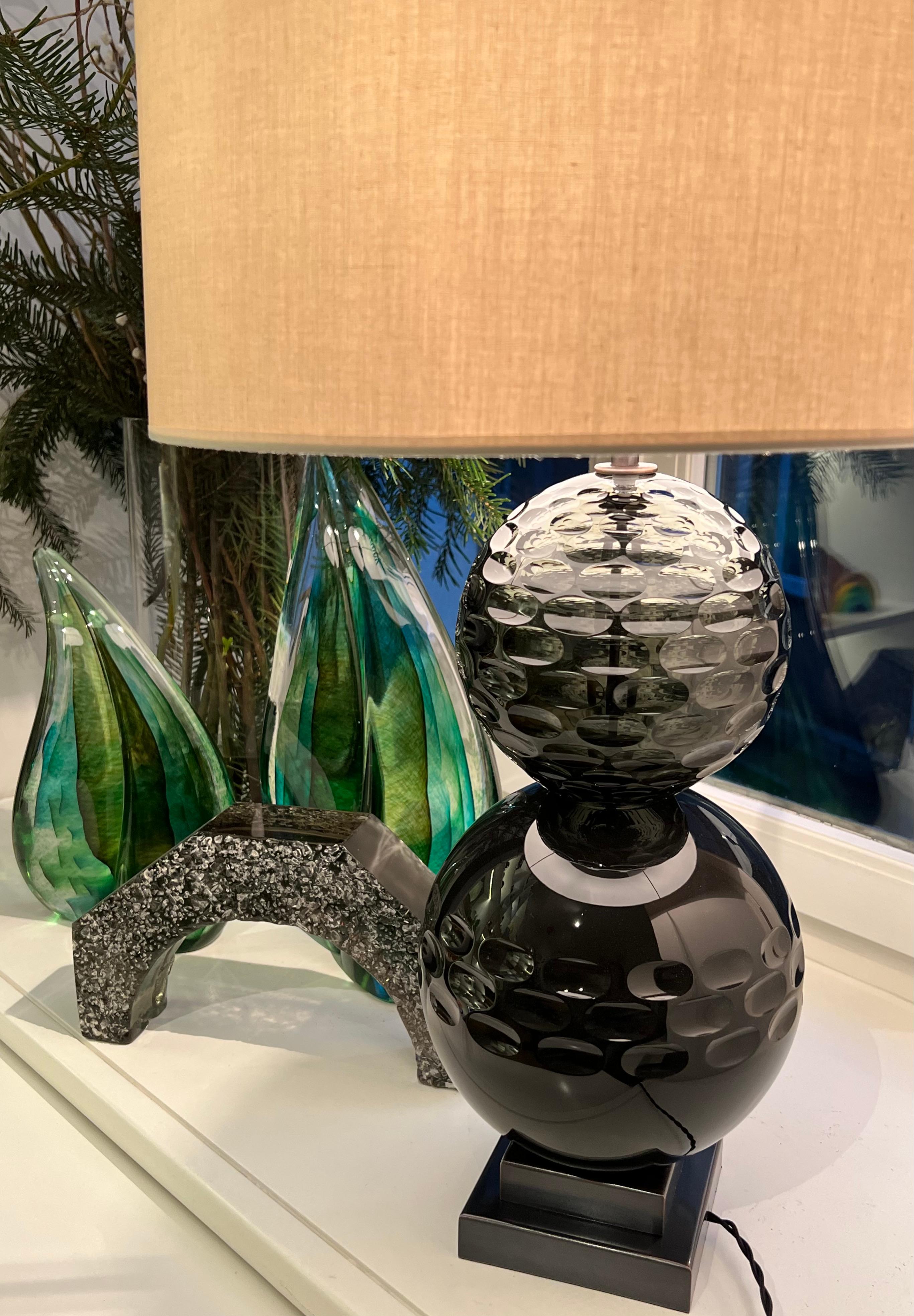 The mouth blown and hand carved striking olive and amethyst glass globes are mouth blown and hand carved. The glass globes are about 20 cm and 16 cm in diameters and becomes the focal point in any interior. The metal base, woven electric cord and