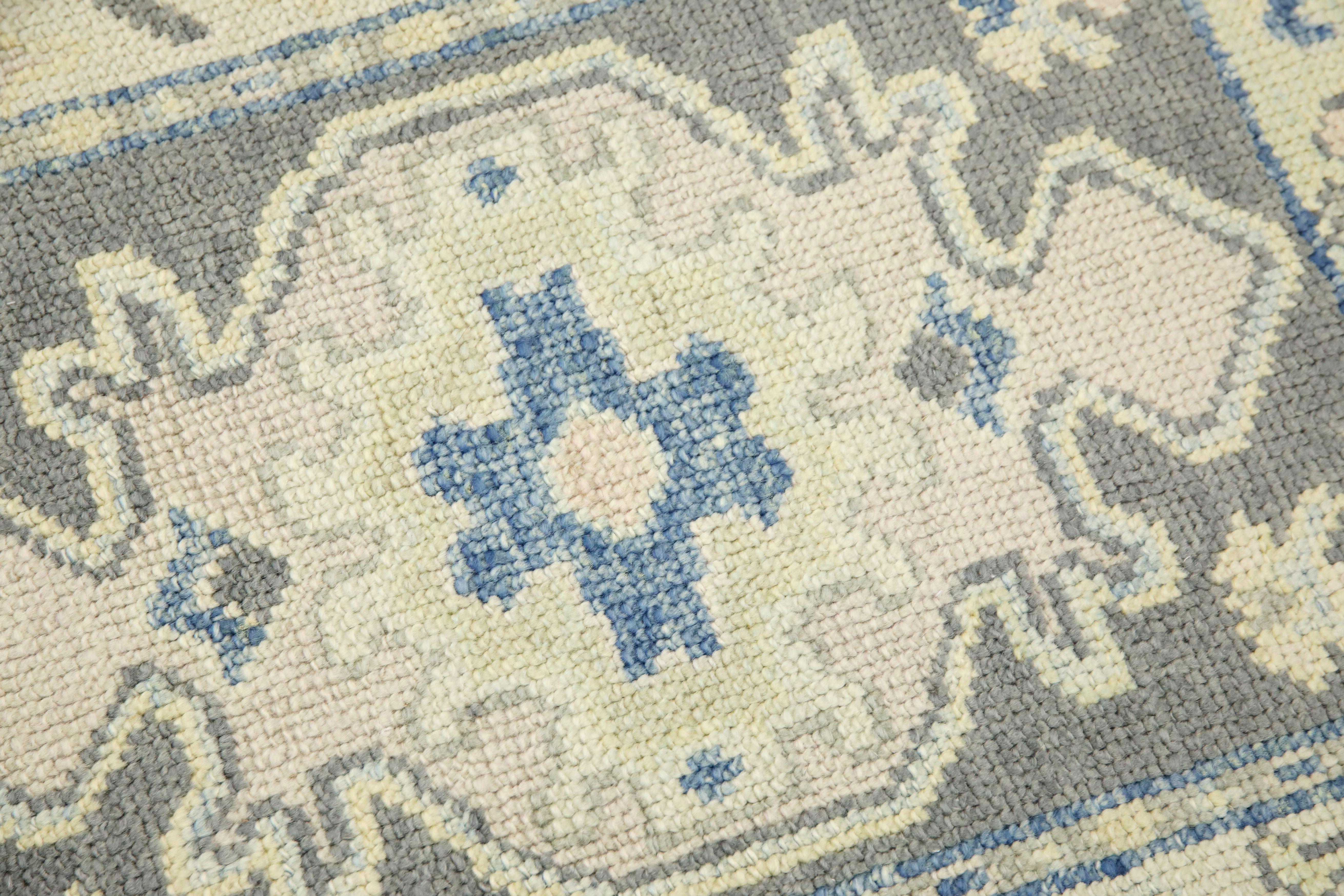 This modern Turkish Oushak rug is a stunning piece of art that has been handwoven using traditional techniques by skilled artisans. The rug features intricate patterns and a soft color palette that is achieved through the use of natural vegetable