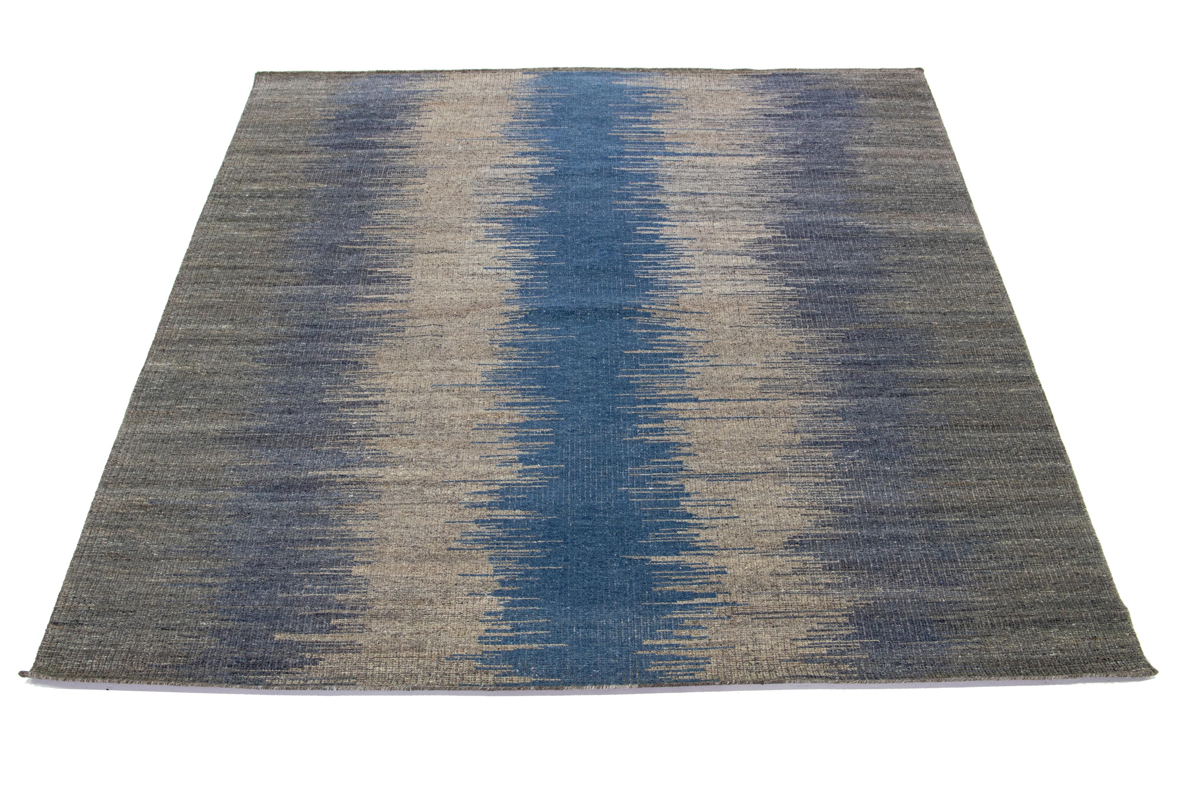 This Indian rug features a modern Kilim flatweave style made from wool. The rug boasts a gray and blue abstract design.

This rug measures 8'4