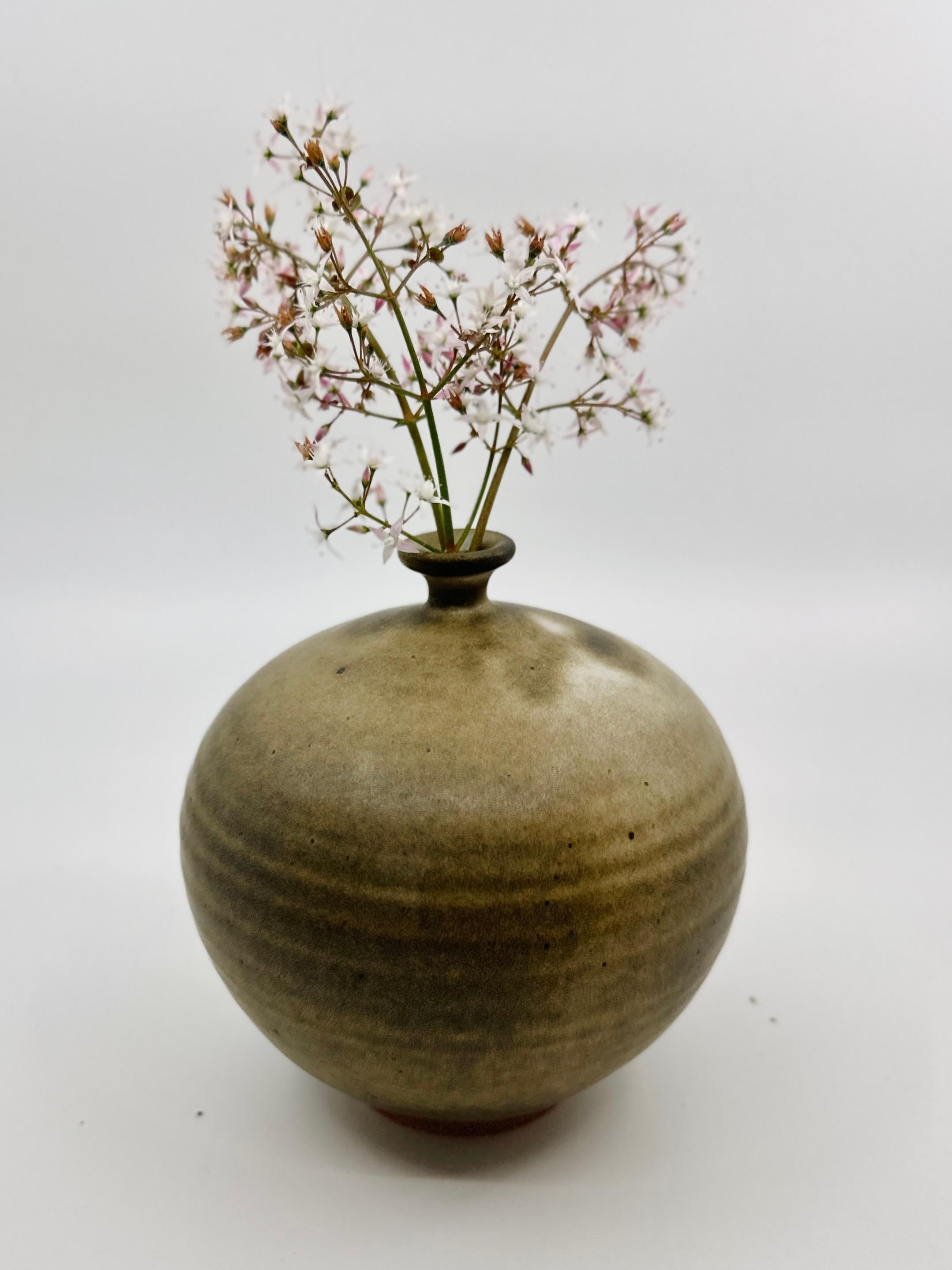 Wheel-thrown little neck vessel in beautiful gray, brown and cream colors. Made from light stoneware, this piece serves as a testament to the timeless beauty of heirloom pottery, bringing an organic serenity to your dearest spaces.

Dimensions: 5.5”