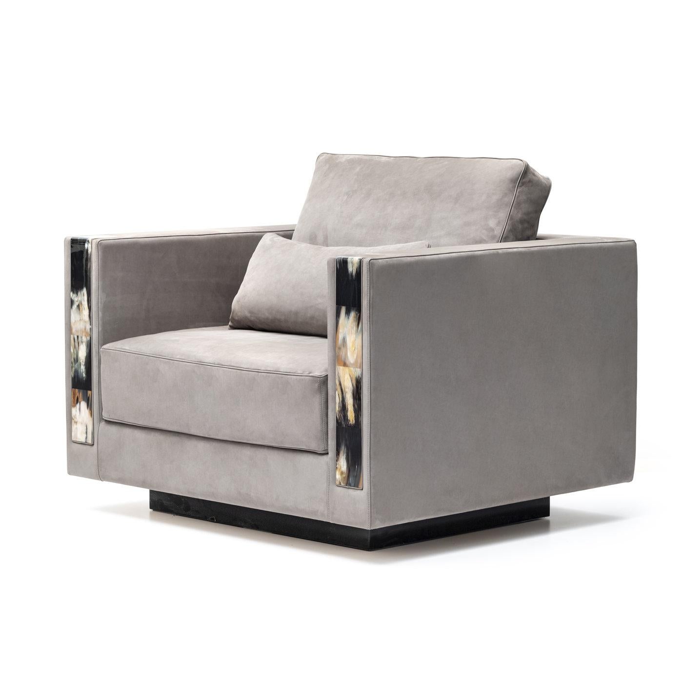 An eye-catching combination of square, bold lines, and prized materials distinguishes this exquisite armchair. It rests on a square, black, wooden base lacquered with a glossy finish and comes with soft cushions as per photo. The square armrests