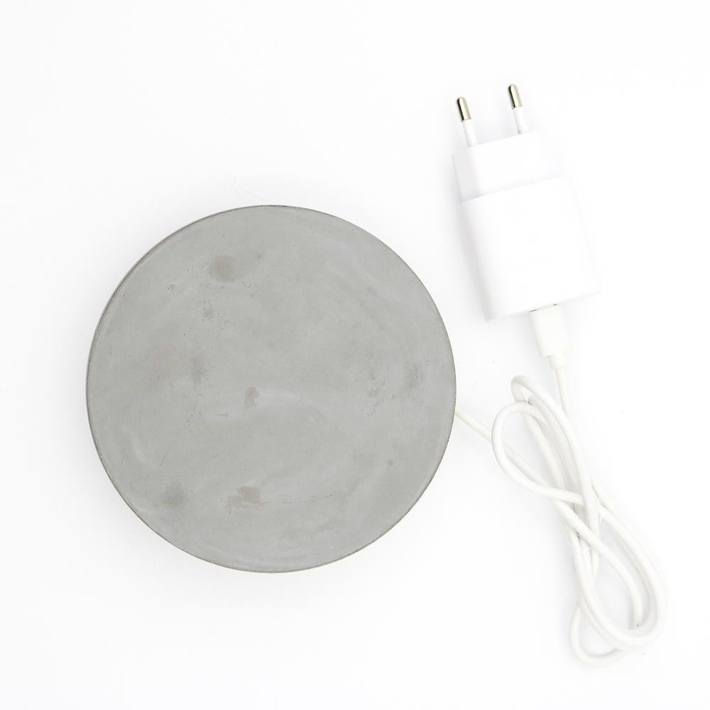 Une base en ciment,
qui recharge rapidement votre téléphone, d'un coup de baguette magique.
 
Un cercle, 
un ciment, 
réalisé avec le soin que requiert le marbre.

Une puissante technologie de charge sans fil garantit une alimentation électrique