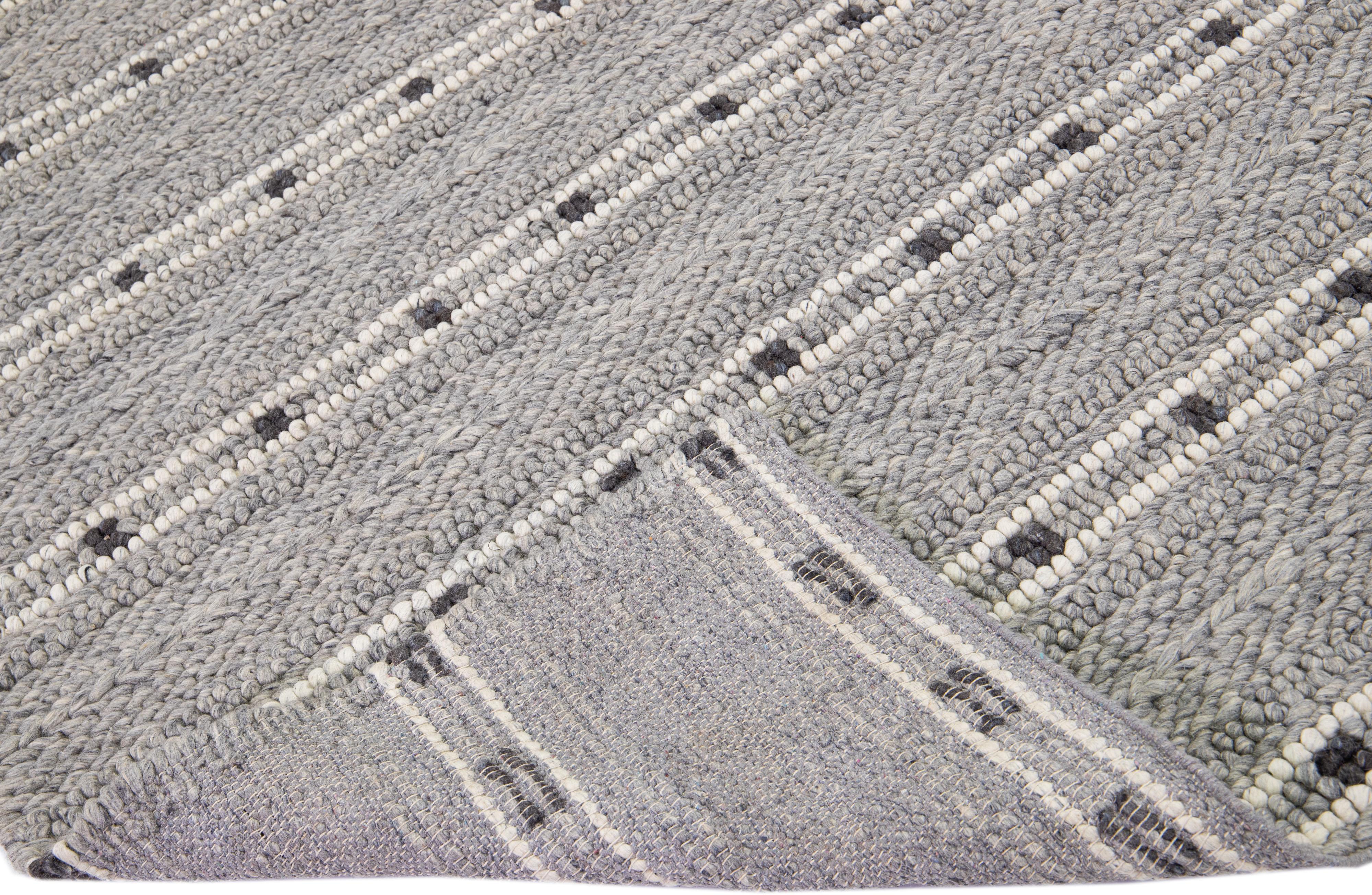 Beautiful Contemporary Thom Filicia Home Collection Rugs. This Indian hand-woven rug is made of wool & viscose and has a gray field and ivory accents all over the design. 
Thom Filicia´s eye for exquisite detailing and beautiful texture shines