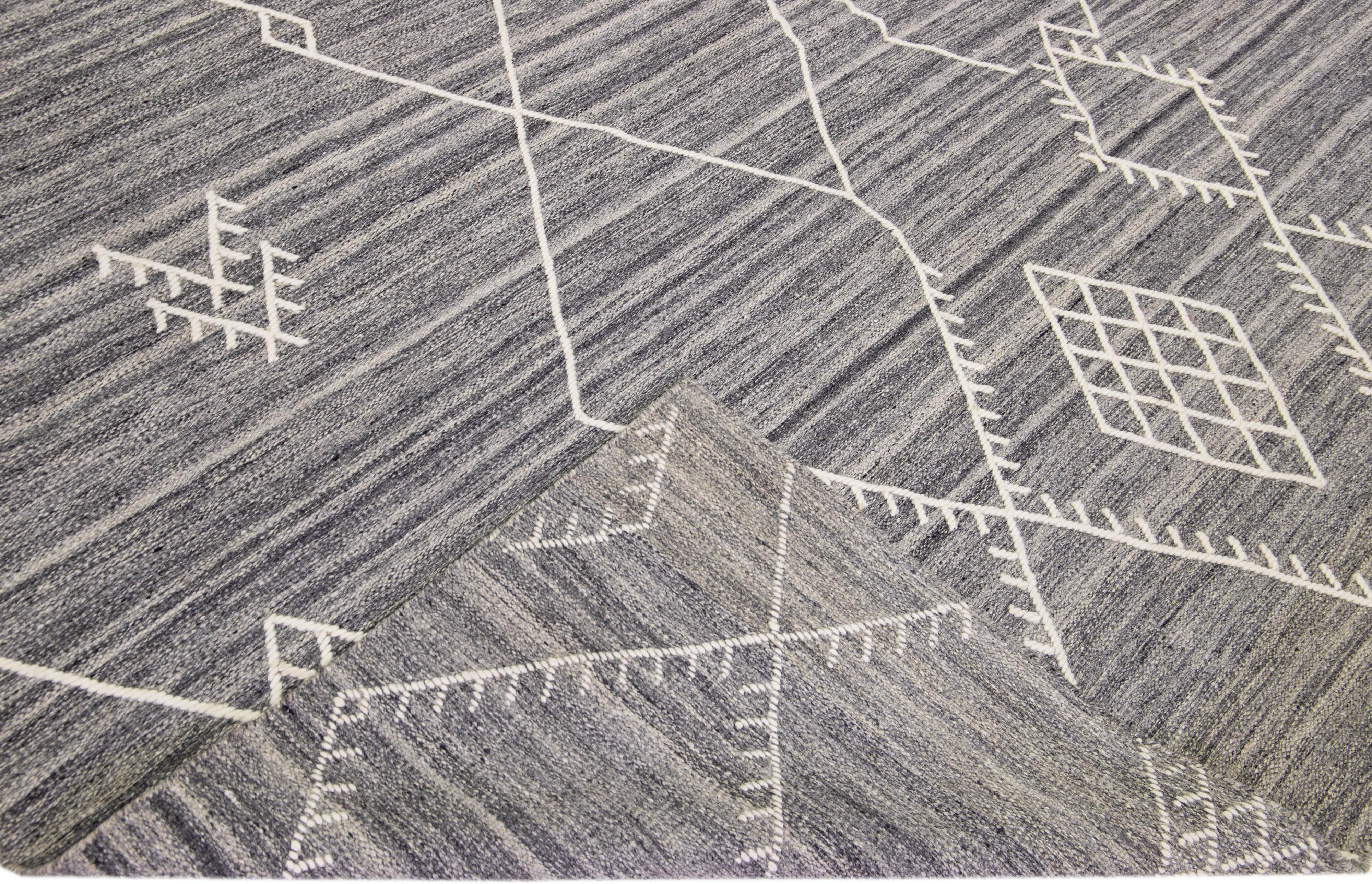 Beautiful kilim handmade wool rug with a gray field. This custom modern flatweave rug of our Nantucket collection has white accents and a gorgeous, all-over geometric coastal design.

This rug measures: 10'4