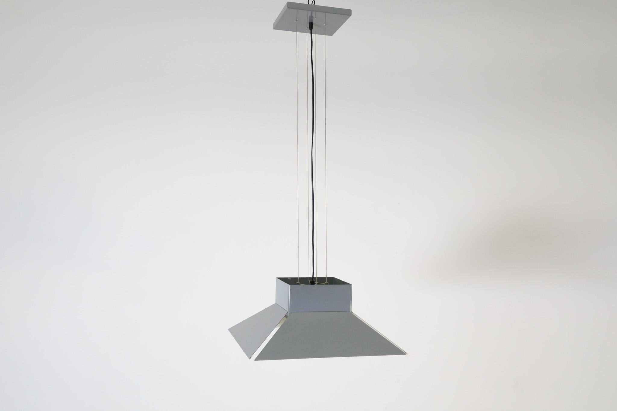 This striking. Mid-Century ceiling pendant was designed by Dutch manufacturer Artimeta in the 1970s. It's a sleek, minimalist light fixture that adds flair to any room. The pendant is made of gray enameled metal and has a black wire cord,