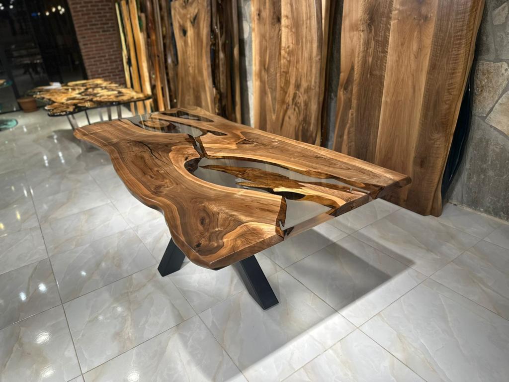 Table de salle à manger en résine époxy noyer gris 

Cette table est fabriquée en bois de noyer. Les veines et la texture du bois décrivent l'aspect d'un bois de noyer naturel.
Elle peut être utilisée comme table de salle à manger ou comme table de