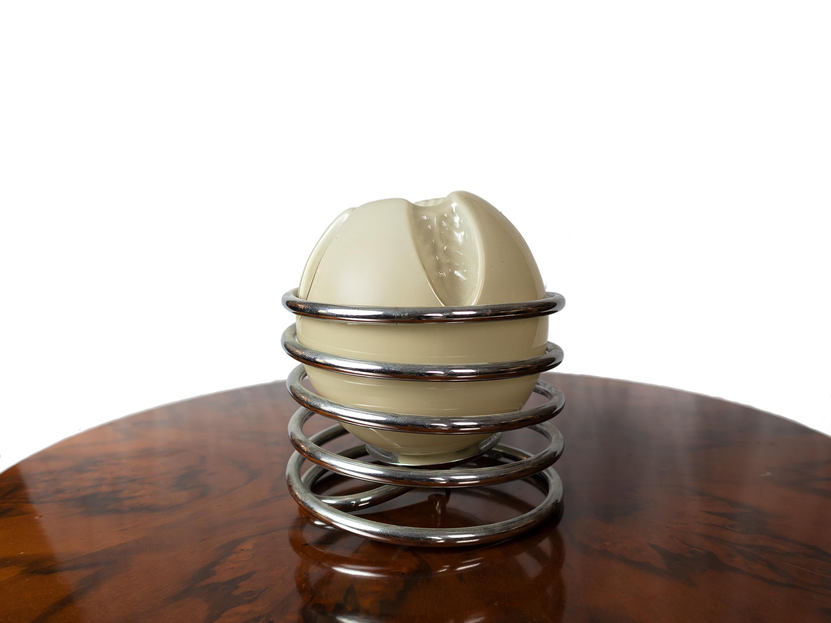 Cette lampe de table italienne moderne du milieu du siècle présente une boule ronde en verre gris entourée d'une spirale en métal chromé. 

Ses petites dimensions en font un complément idéal pour les espaces compacts ou comme pièce d'accent dans les