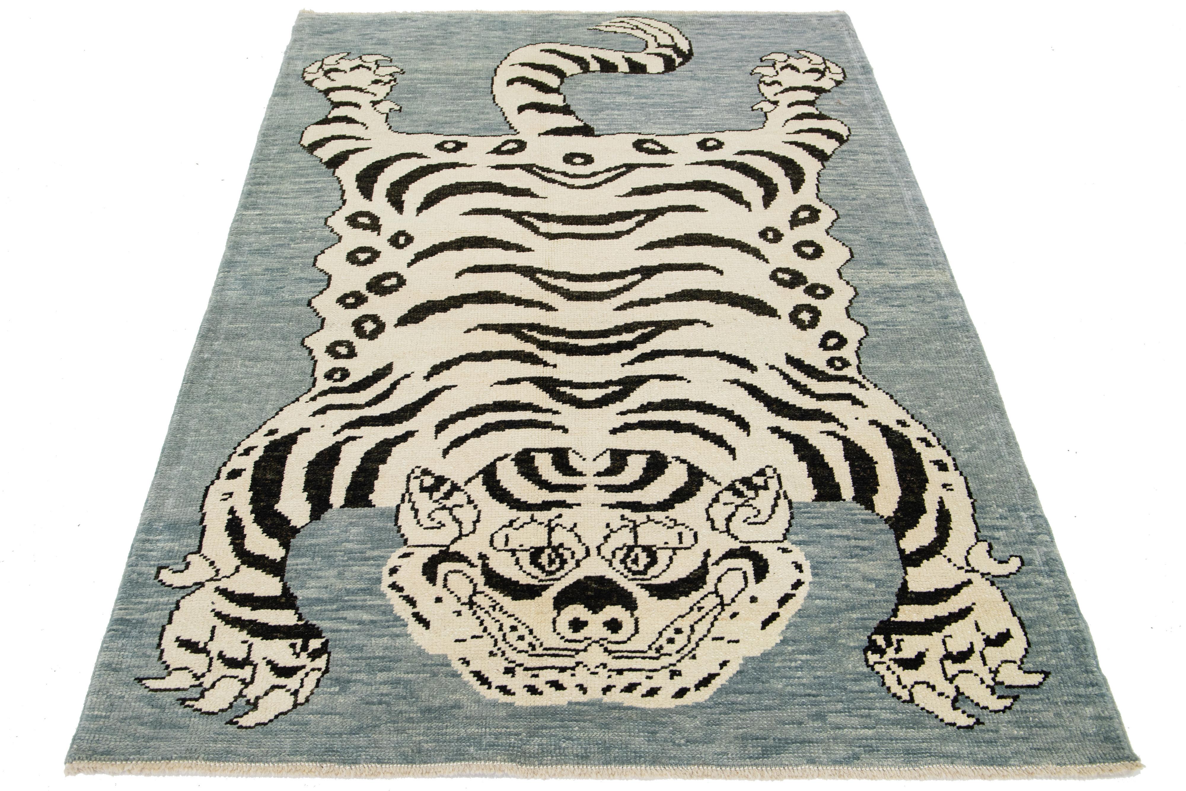 This beautiful Turkish Art Deco wool rug features a gray field with beige accent colors and a stunning tiger pictorial design.

This rug measures 4'9