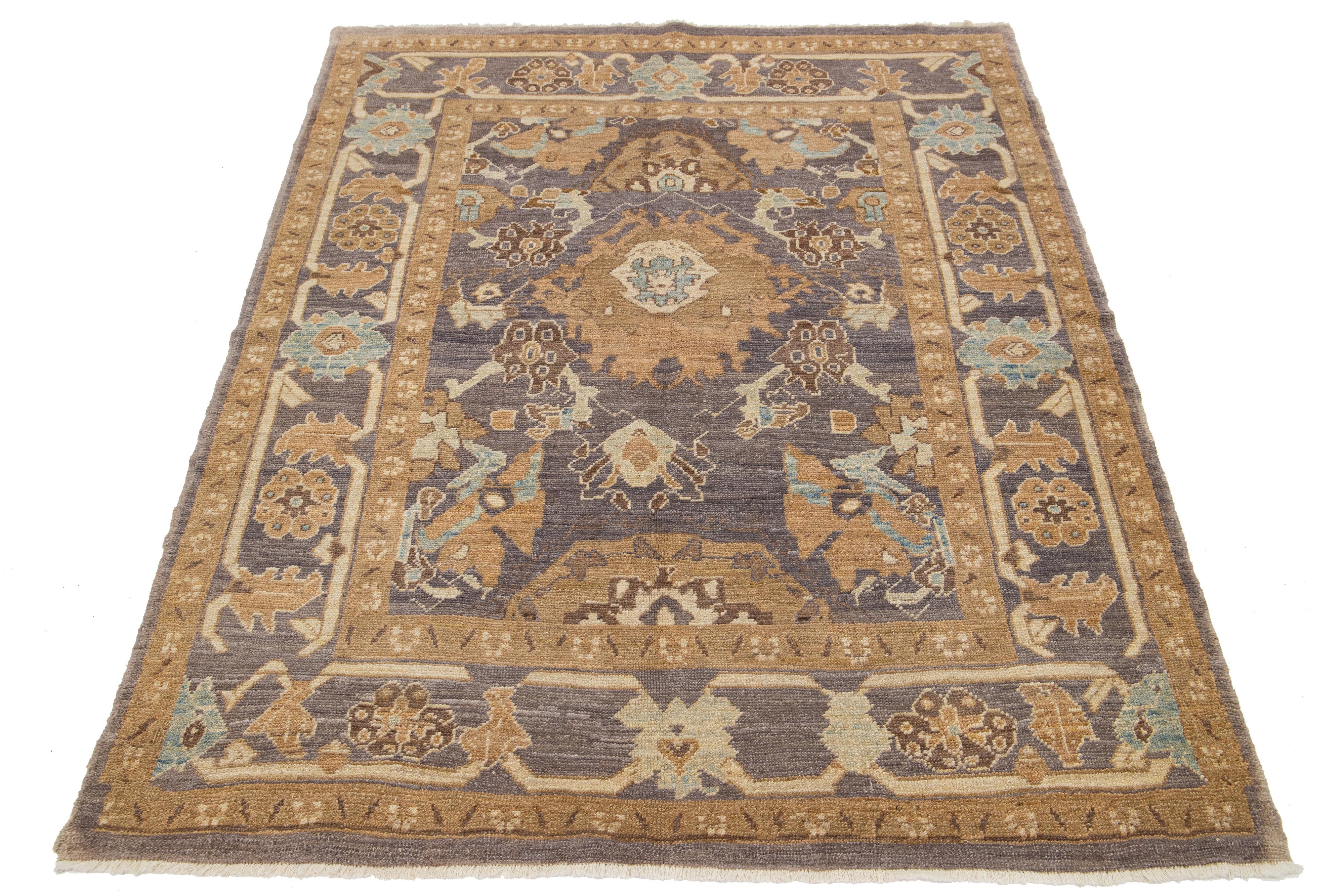 A hand-knotted wool rug with a blue and light brown design on a gray field.

This rug measures at 5'1