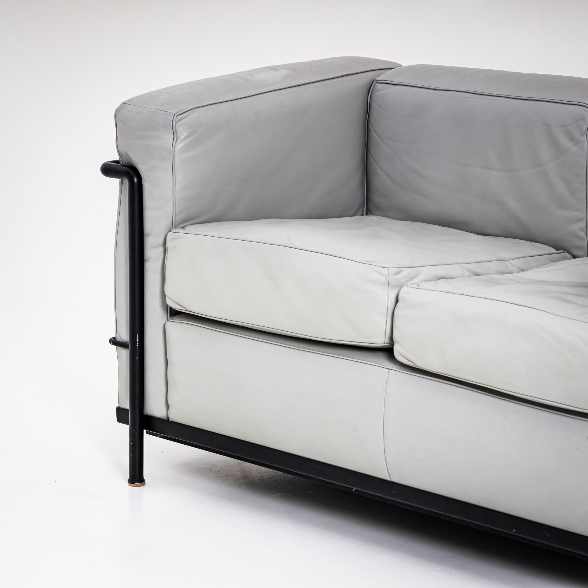 Two-seater leather sofa Grand Confort, Petit Modèle, originally designed by Le Corbusier, Pierre Jeanneret, and Charlotte Perriand, produced by Cassina in the 21st century. This version features a black metal frame and silver-gray leather
