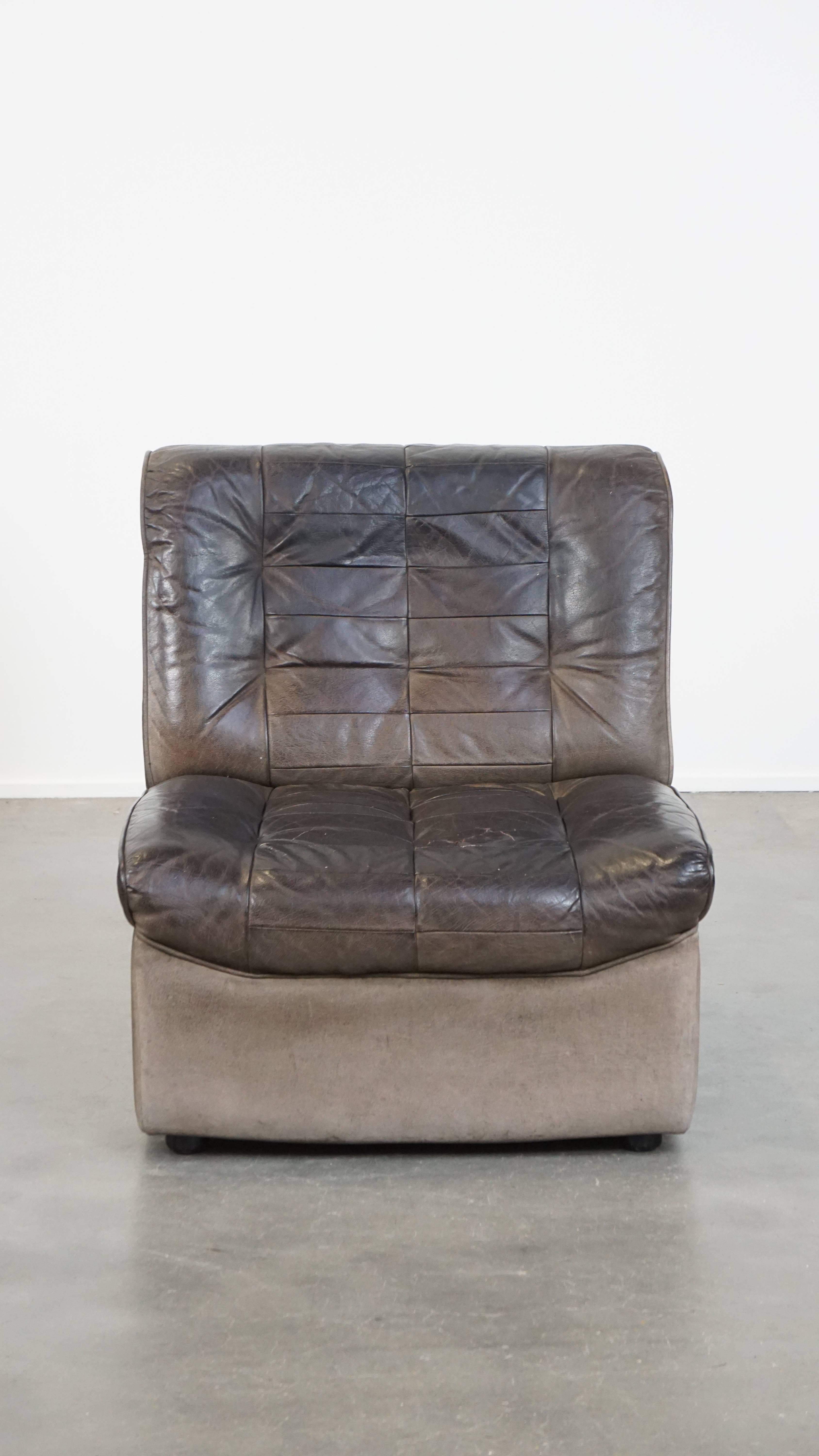 This stylish armchair comes from the 1970s and features a beautiful vintage look combined with excellent lounge seating comfort. Due to years of use, it has acquired some signs of wear, which only add to its unique character. A piece like this is
