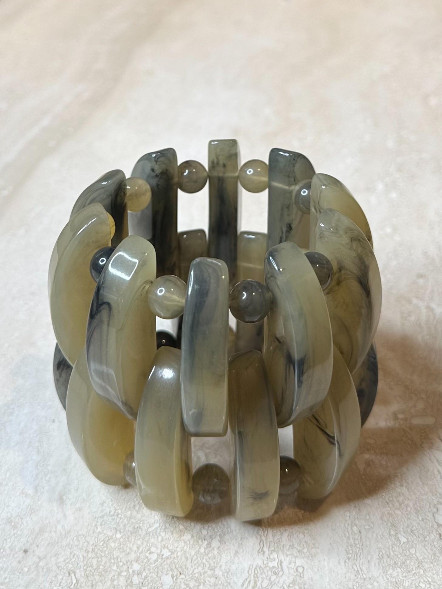 Il bracciale stretch in lucite grigia è un accessorio elegante e minimalista che combina il fascino moderno della lucite con il comfort di un design elastico. Il suo colore grigio neutro lo rende versatile, facile da abbinare a diversi outfit e