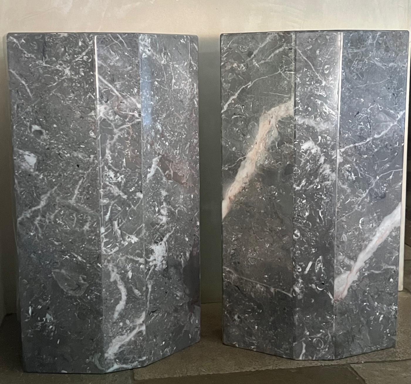 Set of two vintage gray marble columns. The columns have eight flat sides giving them a modern look. Each have white veining that is different on each piece as they are natural marble. The set can be used as side tables or to give height to a room.
