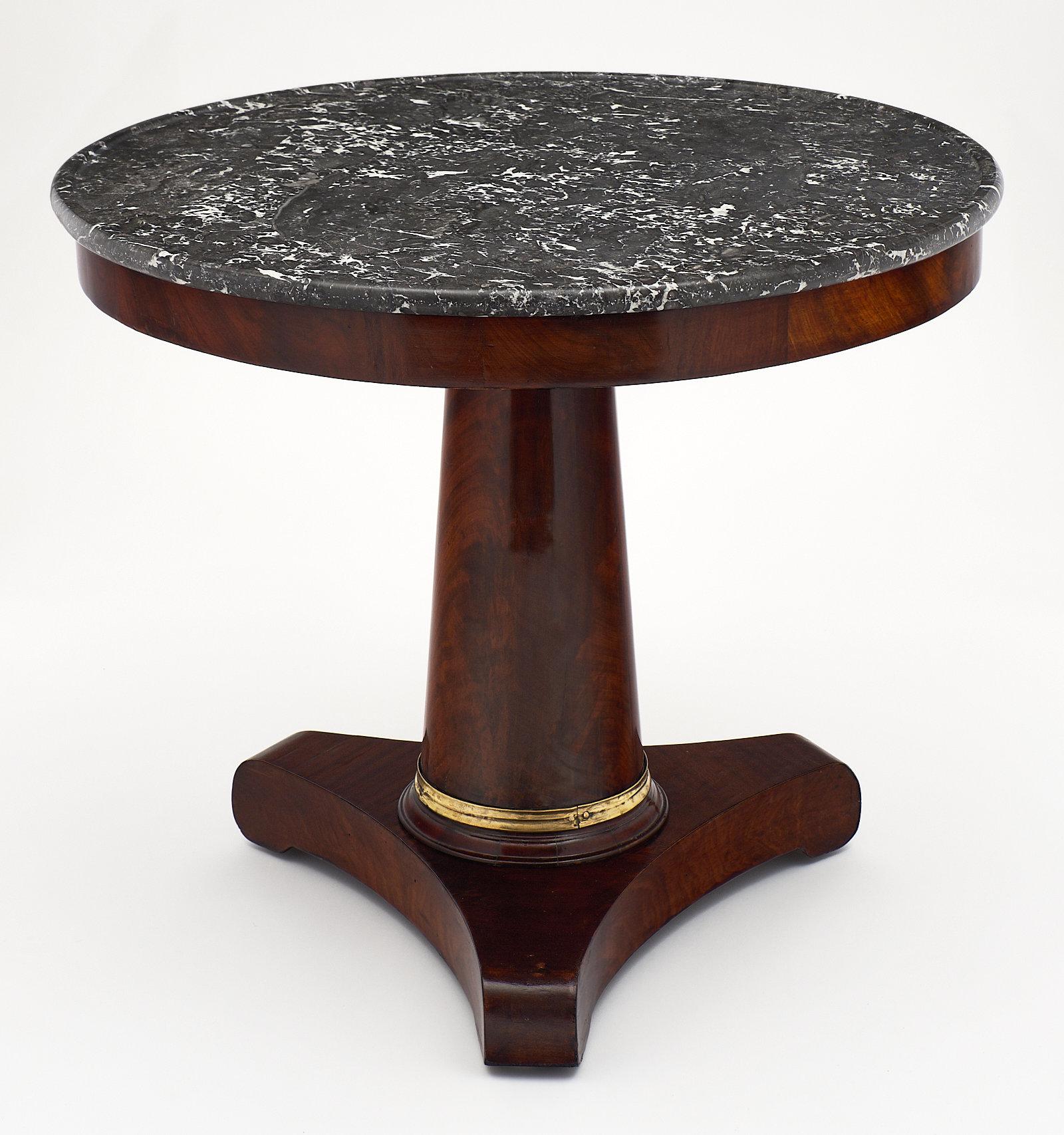 A sleek French Empire period “gueridon” with gray marble top. The base is made of Cuban flamed Mahogany with a tripod center foot. It has been finished with a lustrous French polish. We loved the Saint Anne gray marble top and the gilt bronze accent.