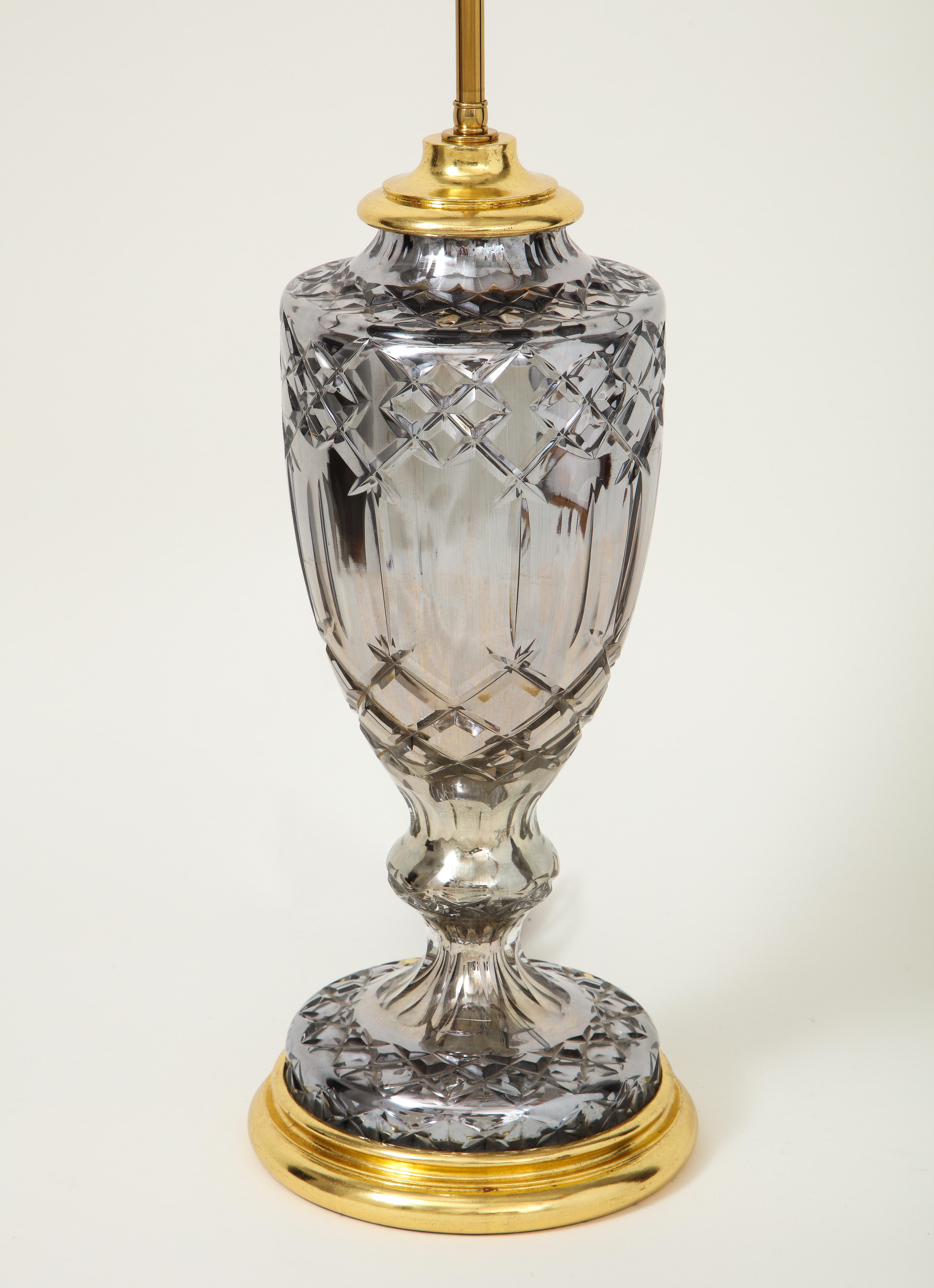 Glamouröse Kombination aus Grau und Gold. In Form einer Vase auf Ständer, angereichert mit geschnittenem Windelwerk. Auf einem gedrechselten, vergoldeten Sockel montiert und mit einer verstellbaren Stange und zwei Lampenfassungen versehen. Höhe bis