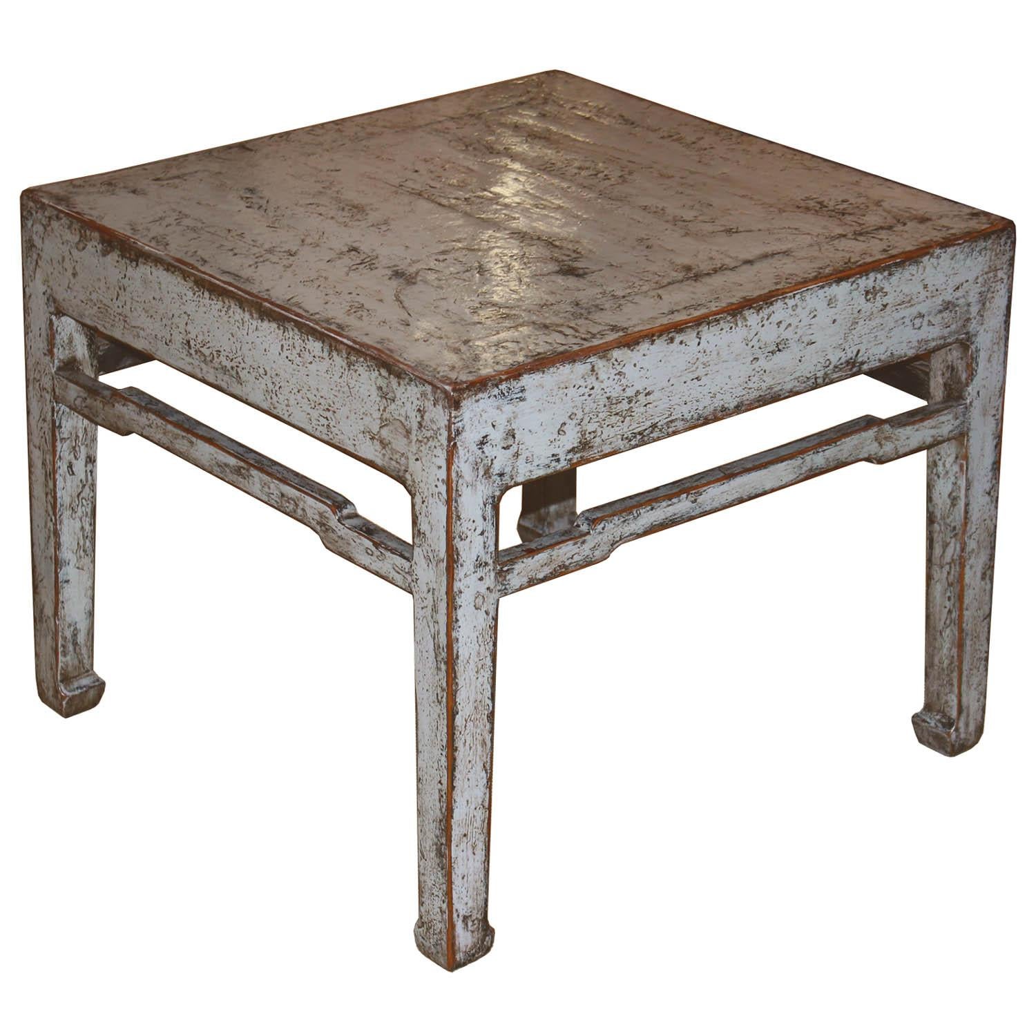 Square ming-style table with hand rubbed edges, horse hoof--style feet and support bars can be placed in front of a small sofa or as a side table next to an arm chair with a lamp and accessories on top.