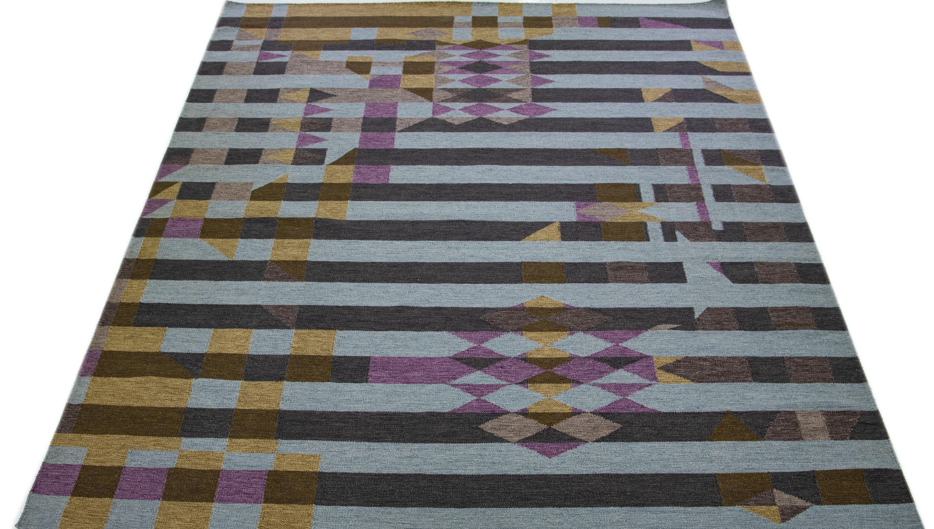 Elevate your interior decor with ease by adding this handmade Indian rug to your home. Featuring a modern interpretation of the traditional Kilim flatweave technique, this piece boasts high-quality wool and a chic gray color palette for a