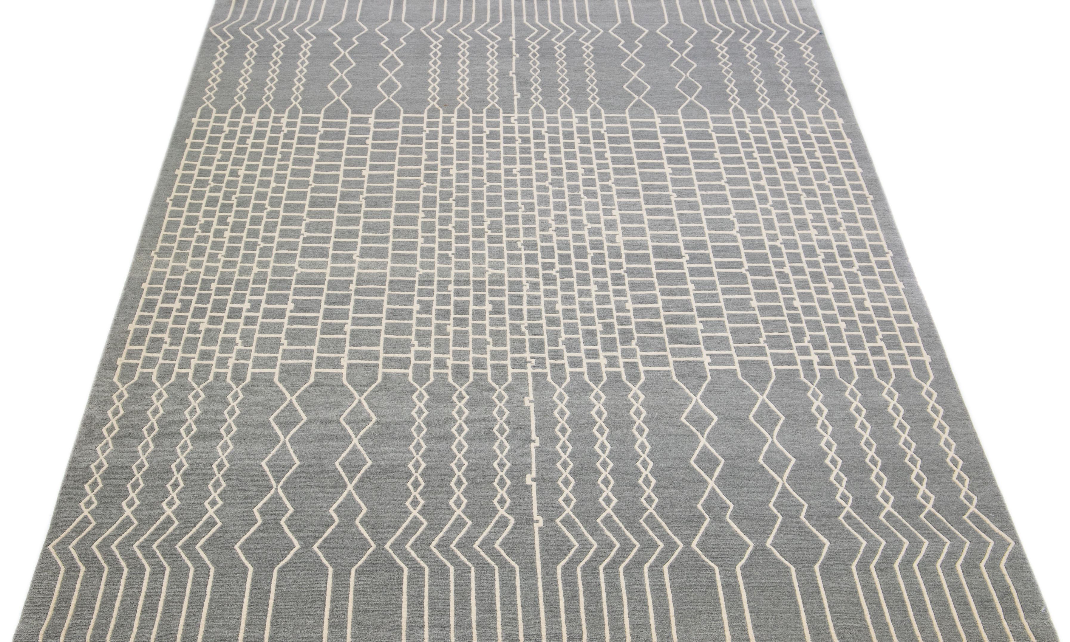 This stunning contemporary rug from Tibet is expertly crafted by hand using wool and silk and boasts a striking gray-silver field. Adding to its charm is an all-over abstract geometric pattern in ivory.

This rug measures 6' x 9'.