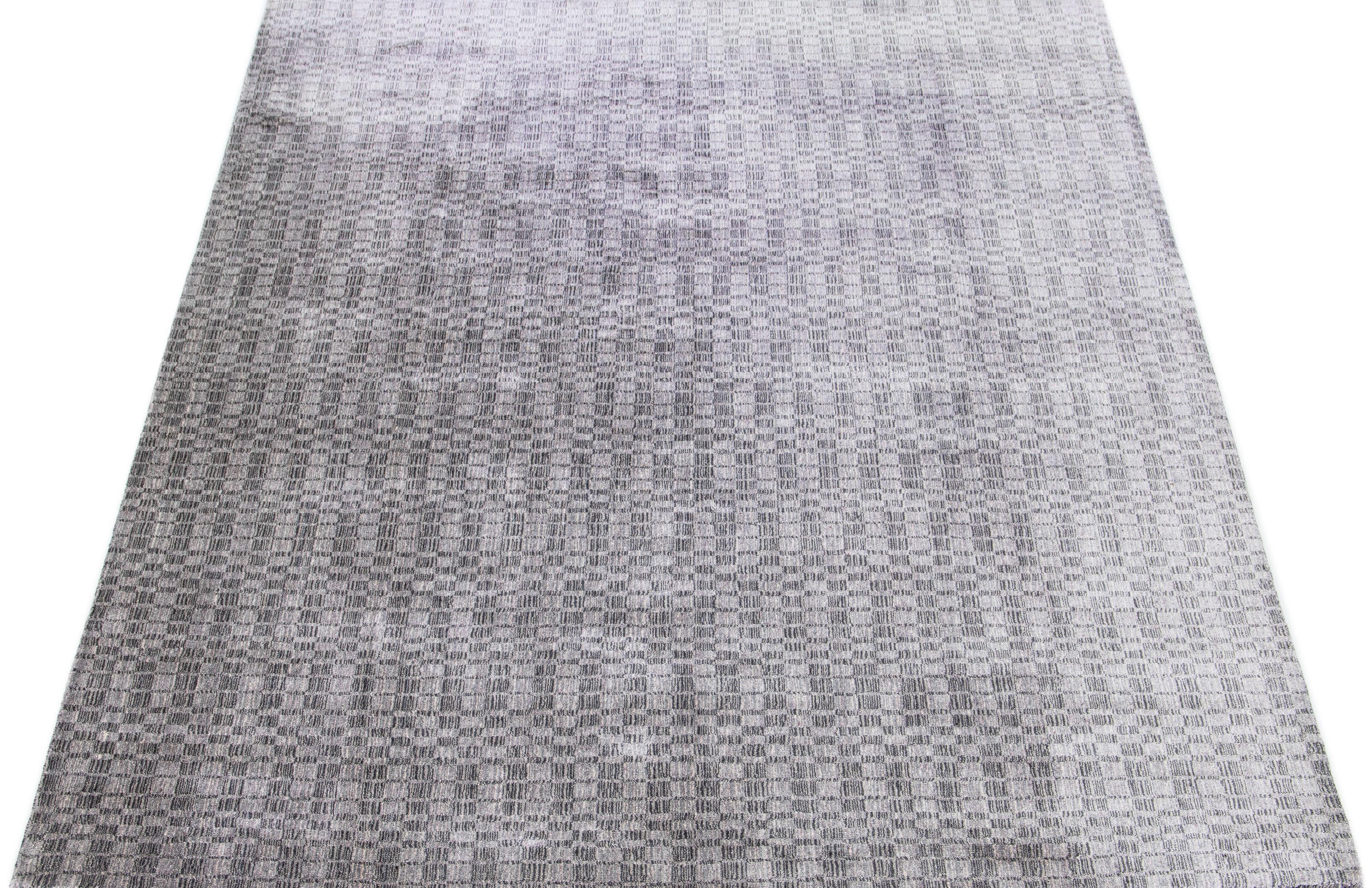Méticuleusement confectionné à la main à partir d'un mélange de soie et de laine, ce tapis contemporain exquis présente une superbe base grise parfaitement accentuée par un séduisant motif géométrique dans des tons argentés.

Ce tapis mesure 9' x