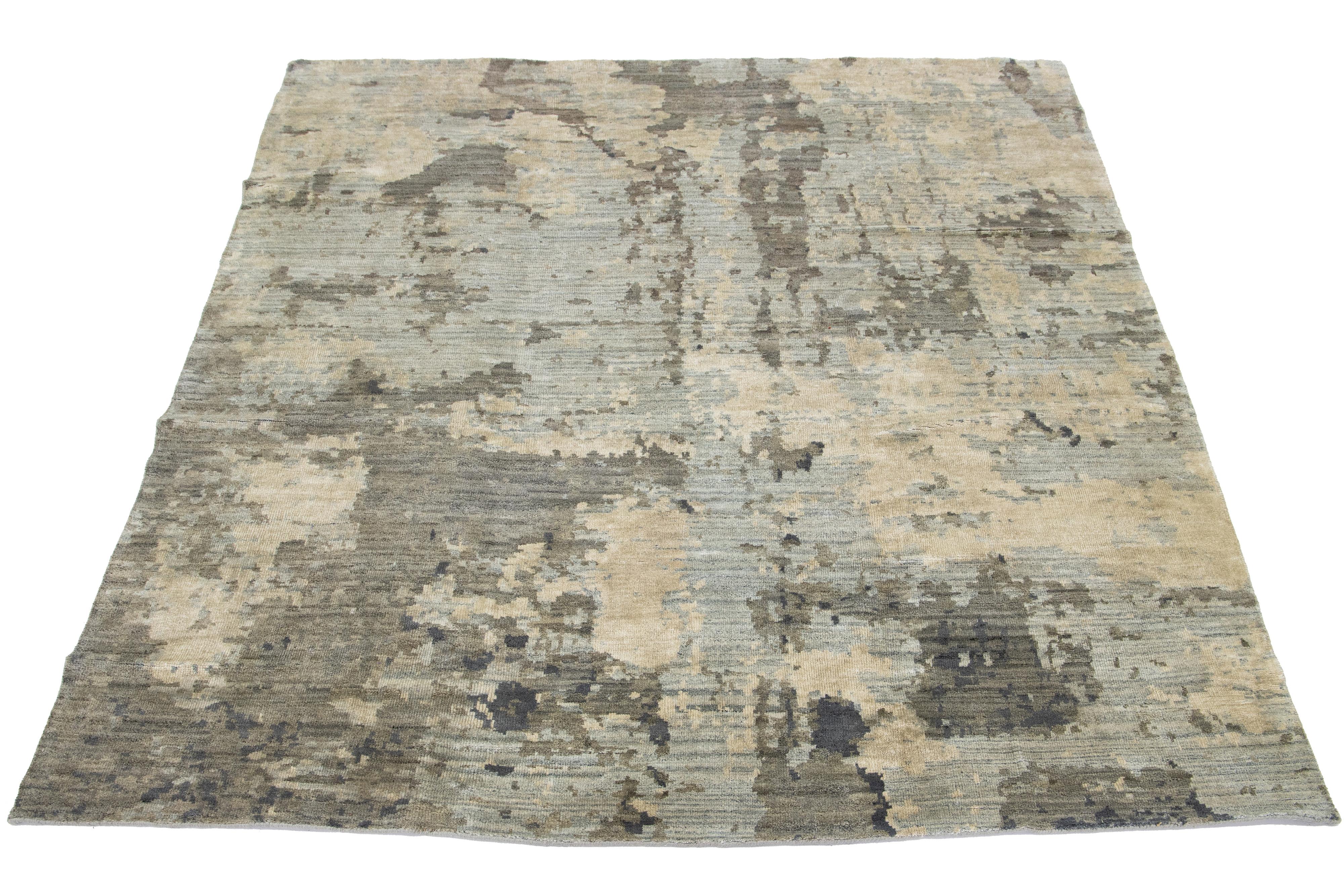 Dieser schöne, moderne, handgeknüpfte Teppich ist aus Wolle und Seide gefertigt und zeigt ein Farbfeld aus Beige und Grau. Der Teppich hat ein atemberaubendes abstraktes Allover-Muster.

Dieser Teppich misst 7'10