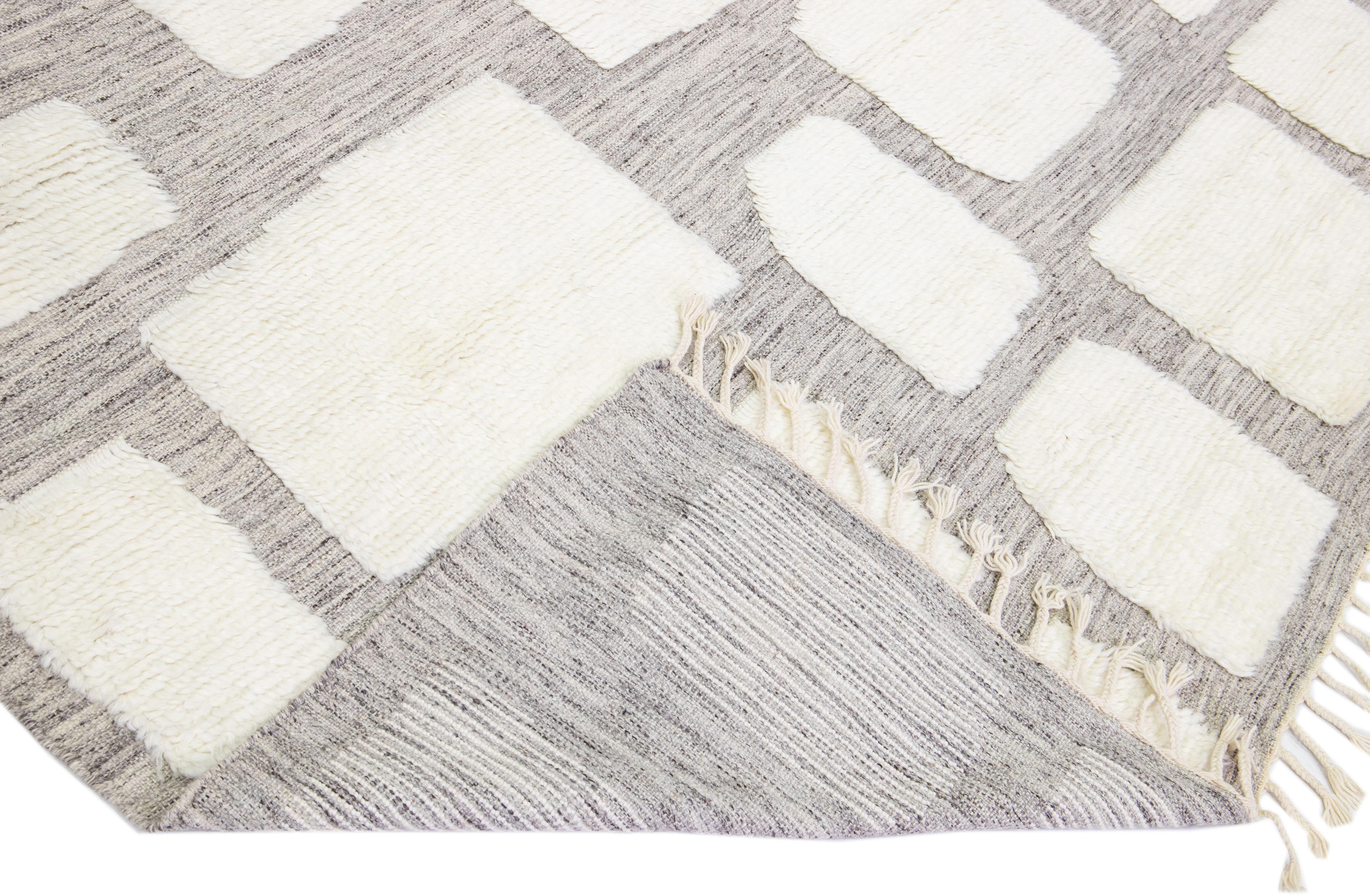 Beautiful modern Moroccan style hand-knotted wool rug with a light gray field and ivory accents in a gorgeous geometric high pile design.

This rug measures: 9'10