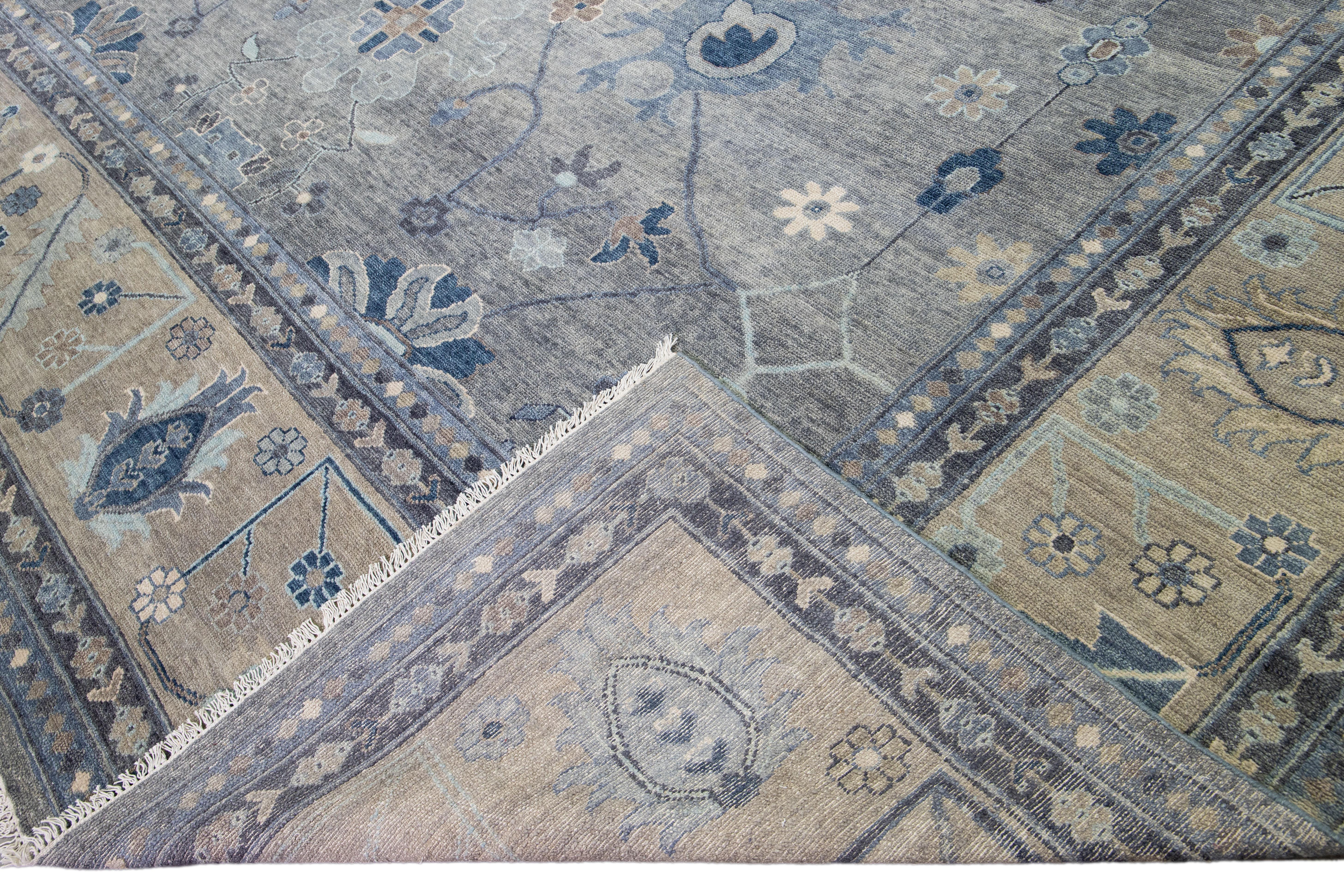 Beautiful modern Oversize Oushak hand-knotted wool rug with a gray field. This Oushak rug has a beige designed frame and blue accents all over a gorgeous floral design.

This rug measures 16' x 20'.

Our rugs are professional cleaning before