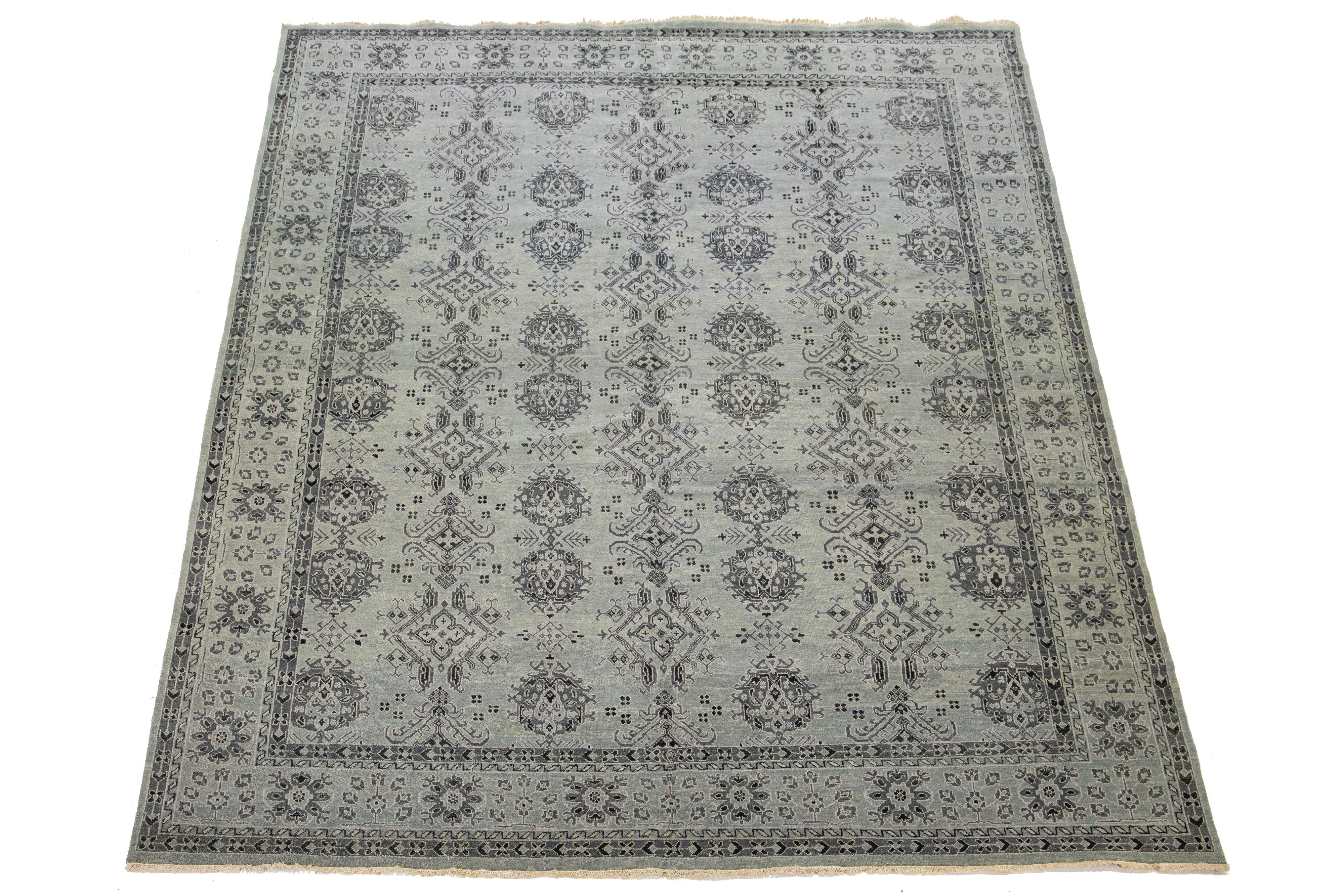 Ce tapis en laine de style Tabriz présente un magnifique motif floral complexe, élégamment mis en valeur sur un fond gris avec des touches de gris et de noir.

Ce tapis mesure 12' x 14'9
