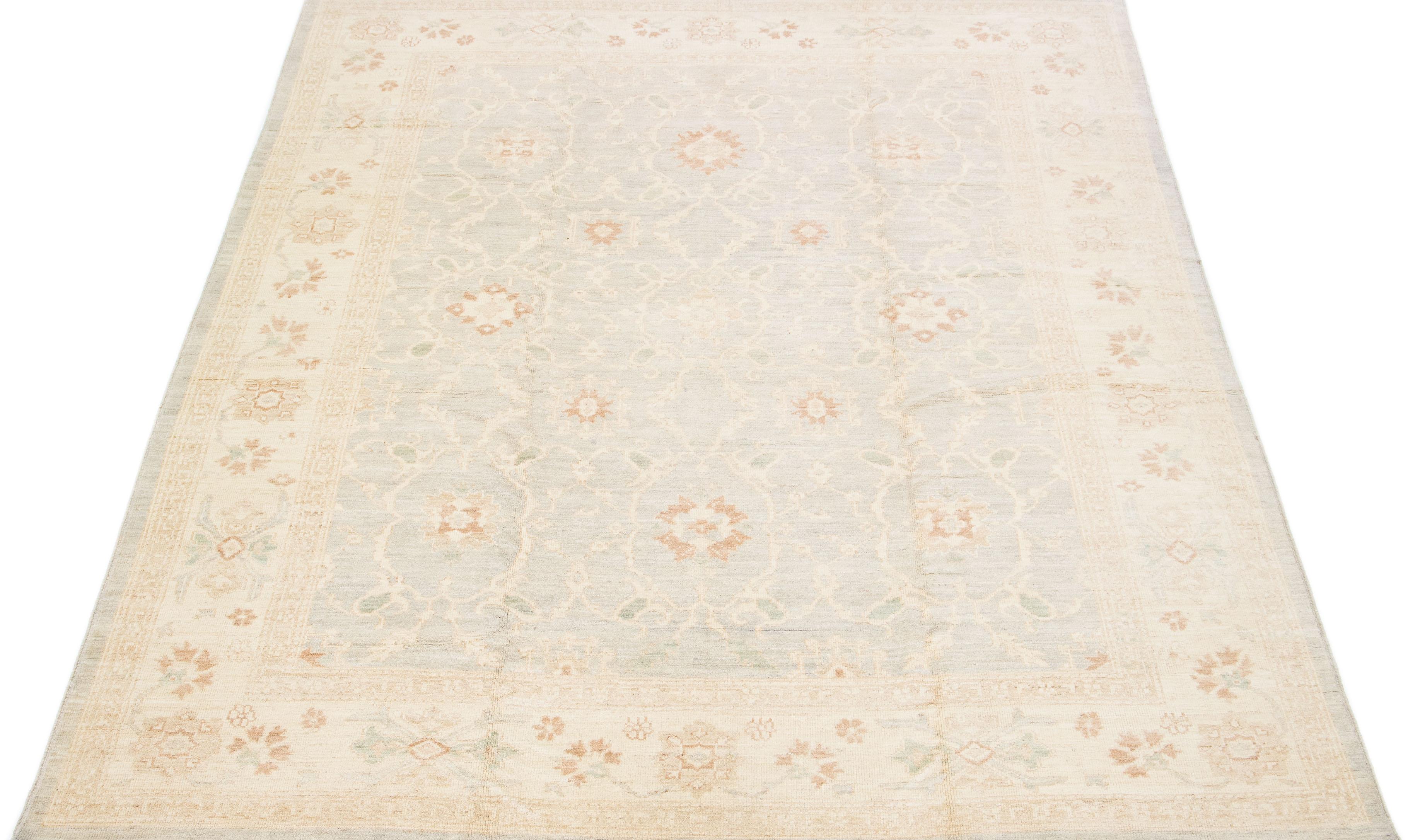 Beautiful modern Oushak hand-knotted wool rug with a gray color field. This Turkish Piece has beige, blue, and brown accent colors in a gorgeous all-over floral design.

This rug measures: 8'10