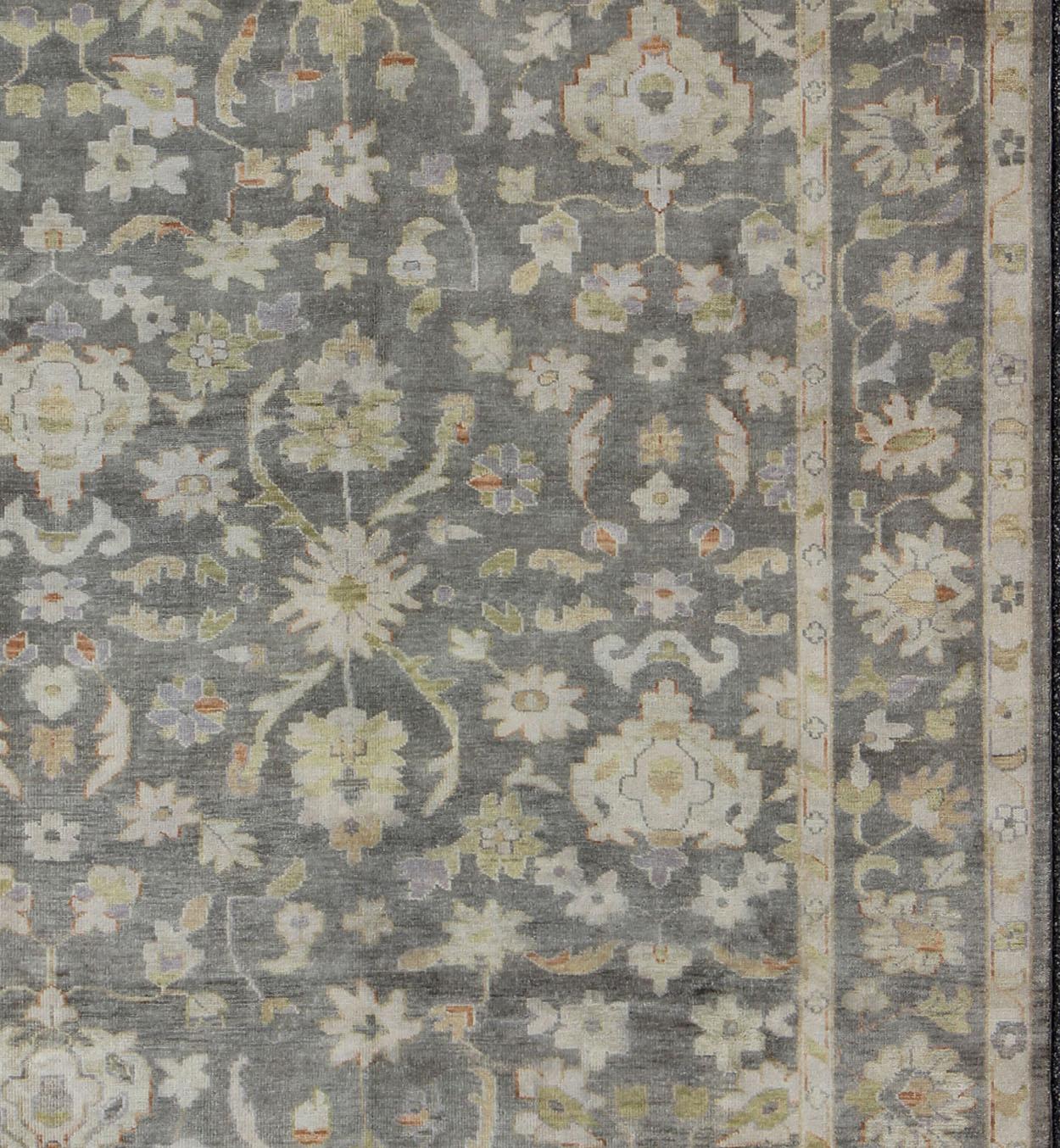 Gray Oushak Rug in floral design, Keivan Woven Arts rug/OB-393788, country of origin / type: India / Oushak, circa Early-21st Century. New Oushak

Measures: 9'0 x 12'0.

This hand-knotted Indian made Oushak rug features a floral design in grey,