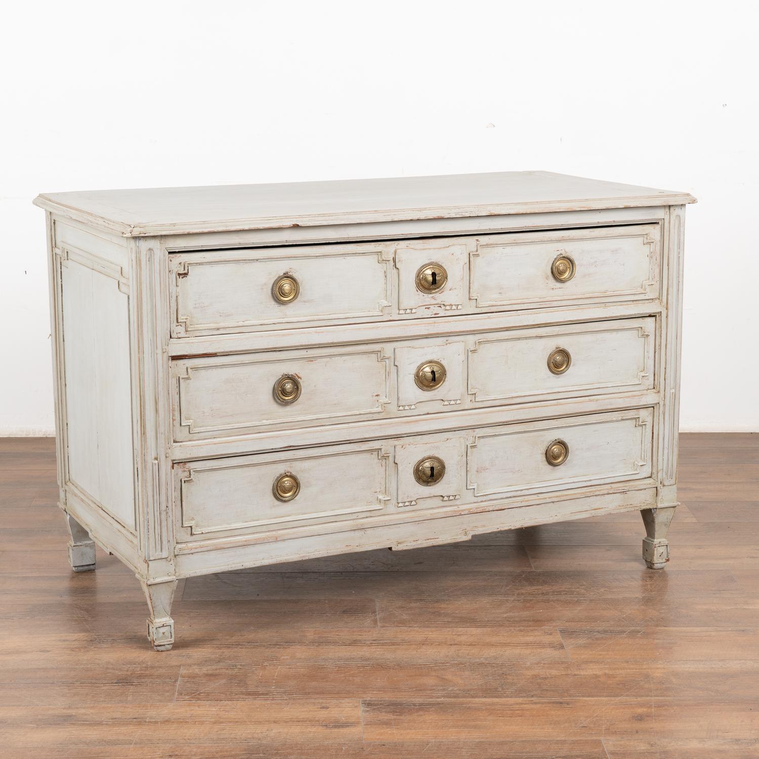 Large pine chest of three drawers with carved panels from France, circa 1820-40.
The newer, professionally applied soft gray painted finish (with pale blue undertones) adds a touch of life and interest while the carved panel drawers and tapered feet