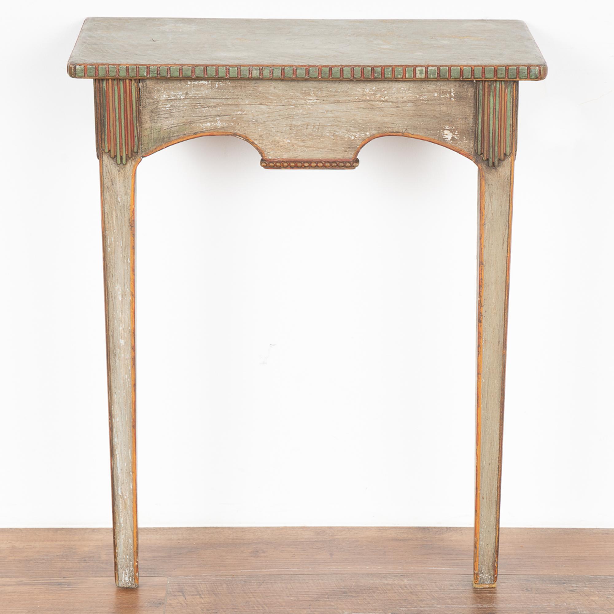 Small side table with tapered legs and dentil molding trim.
It is the beautifully layered gray painted finish with highlights in soft green and red that create the captivating appeal of this special accent table.
Restored, strong and stable it is