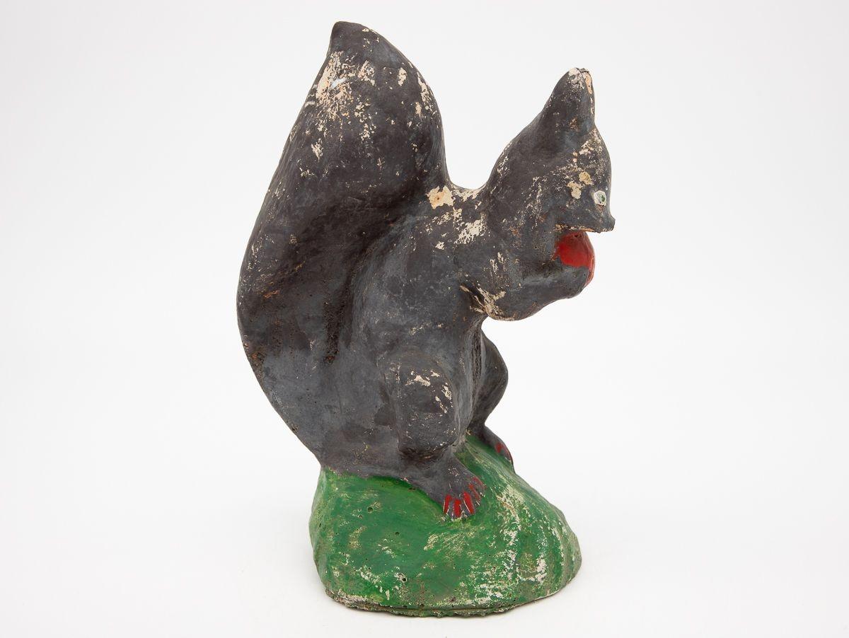 A vintage cast stone squirrel from the mid-20th century. Likely from England, this piece has a naive quality. This garden ornament retains much of its original paint. Wear consistent with age and use.