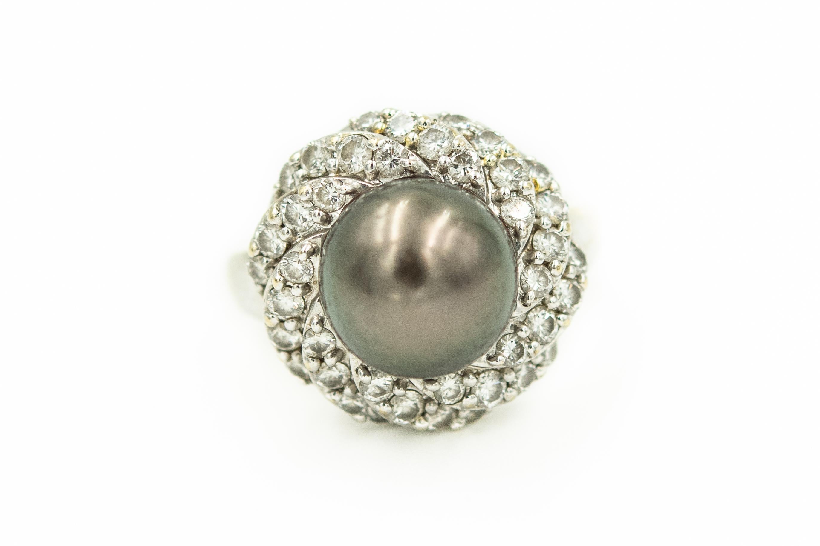 This 18k white gold elegant set features a diamond swirl design around a centrally set gray cultured pearl.  

The ring has a center gray cultured pearl that is approximately 10.5 mm.  It is dark gray with a fair luster and slight blemishes.  It is